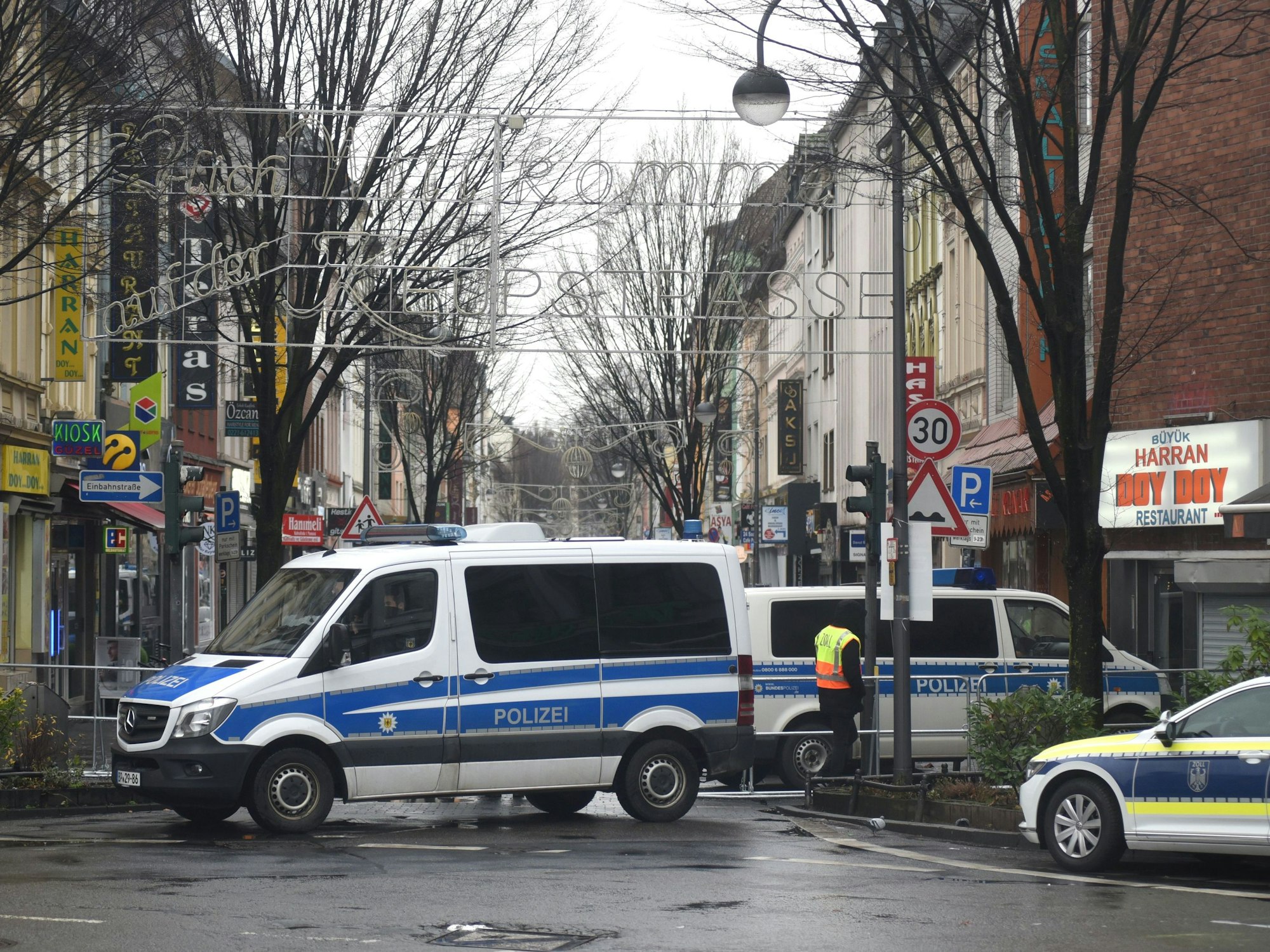 Kölner Polizei steht mit einigen Fahrzeugen am Anfang der Keupstraße in Köln-Mülheim.