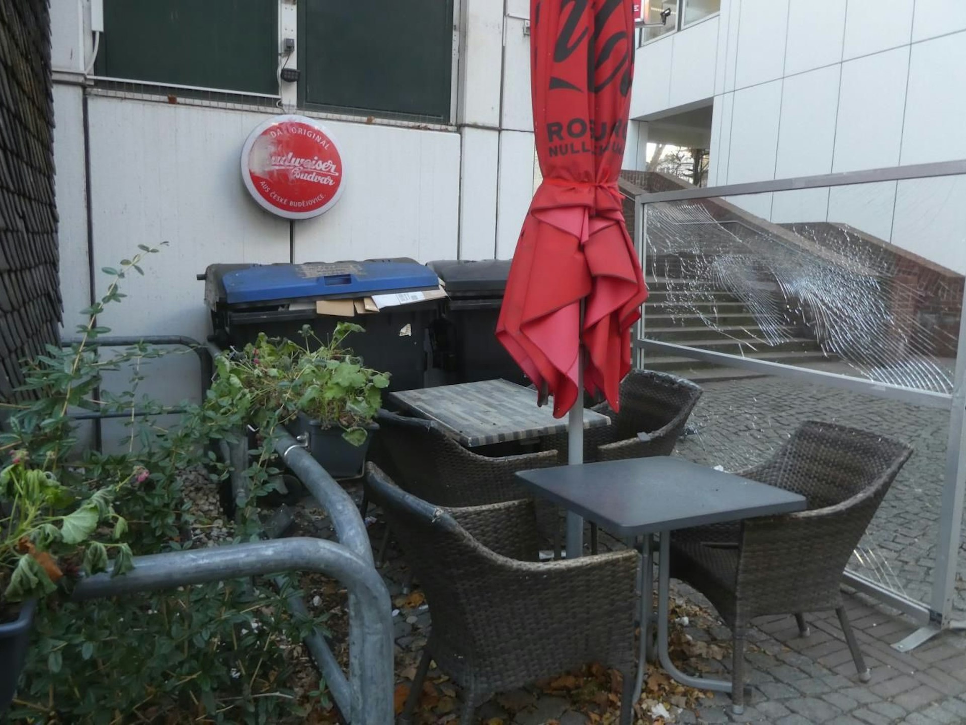 Stühle und Mülltonen an einem Aufgang zur Kirche.