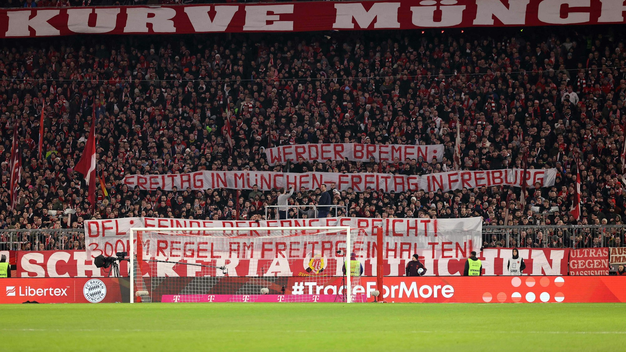Bayern-Fans halten ein Banner auf der Tribüne hoch.