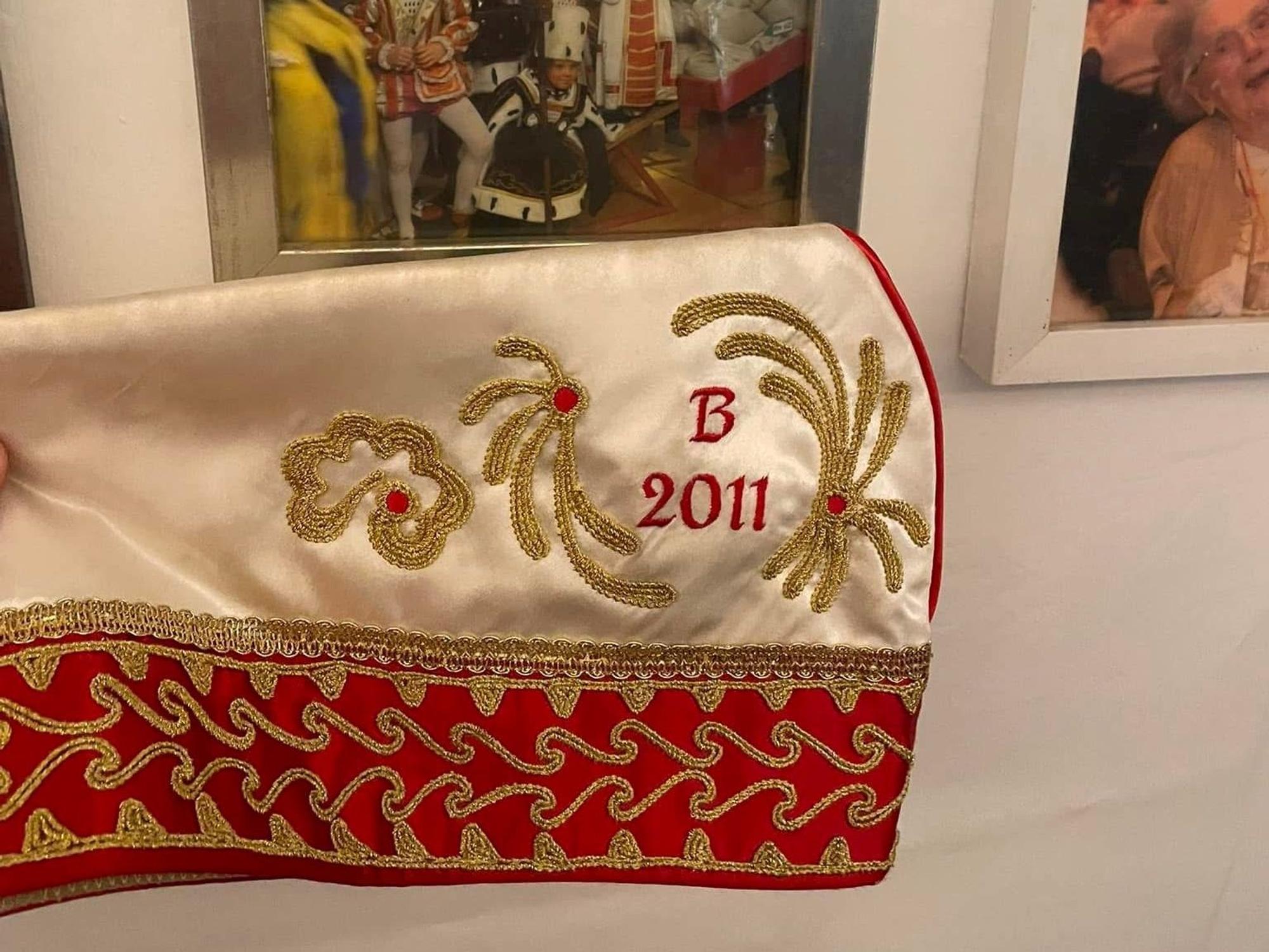Ein Krätzchen liegt auf einem Tisch vor Bilderrahmen.