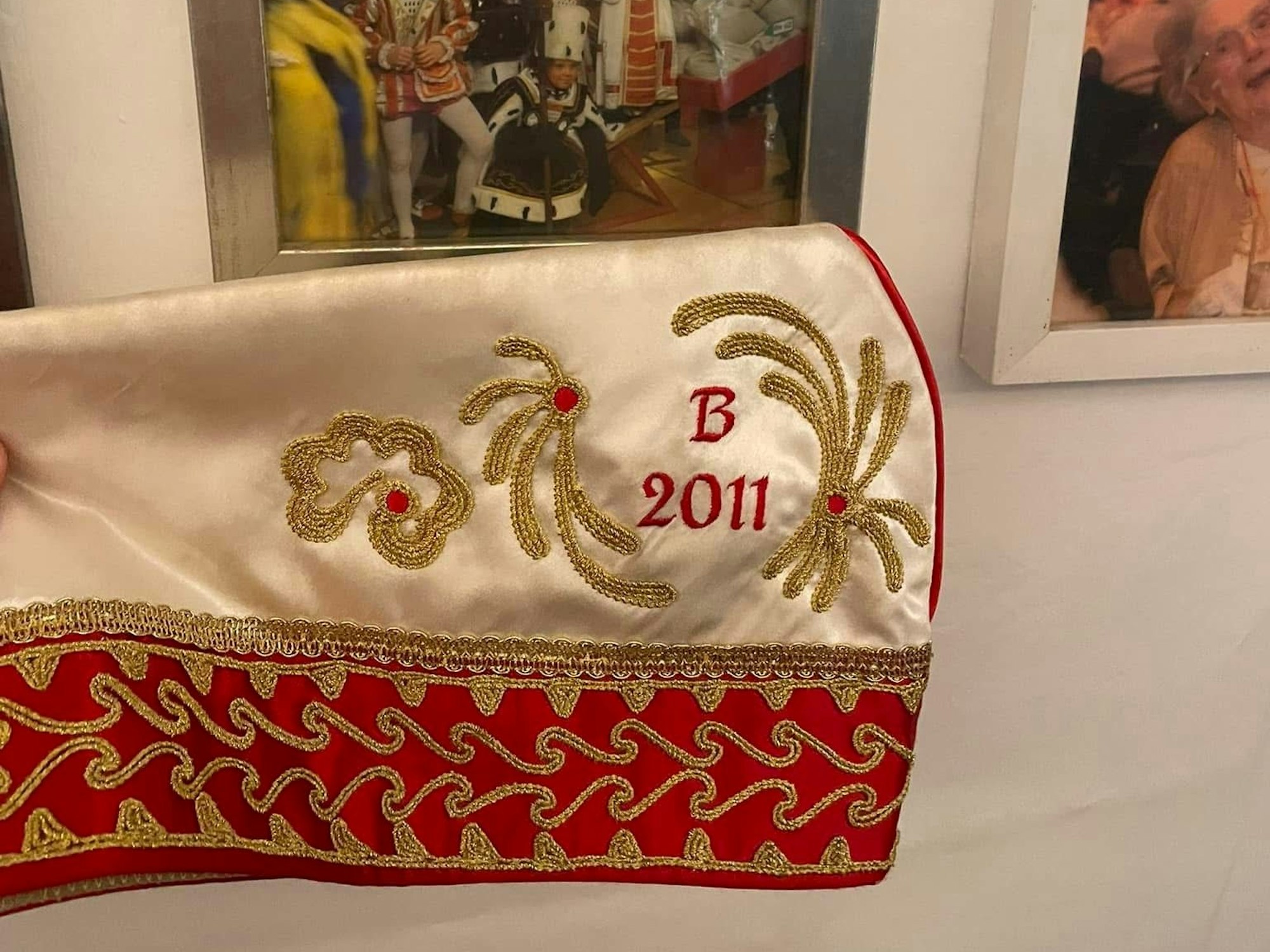 Ein Krätzchen liegt auf einem Tisch vor Bilderrahmen.