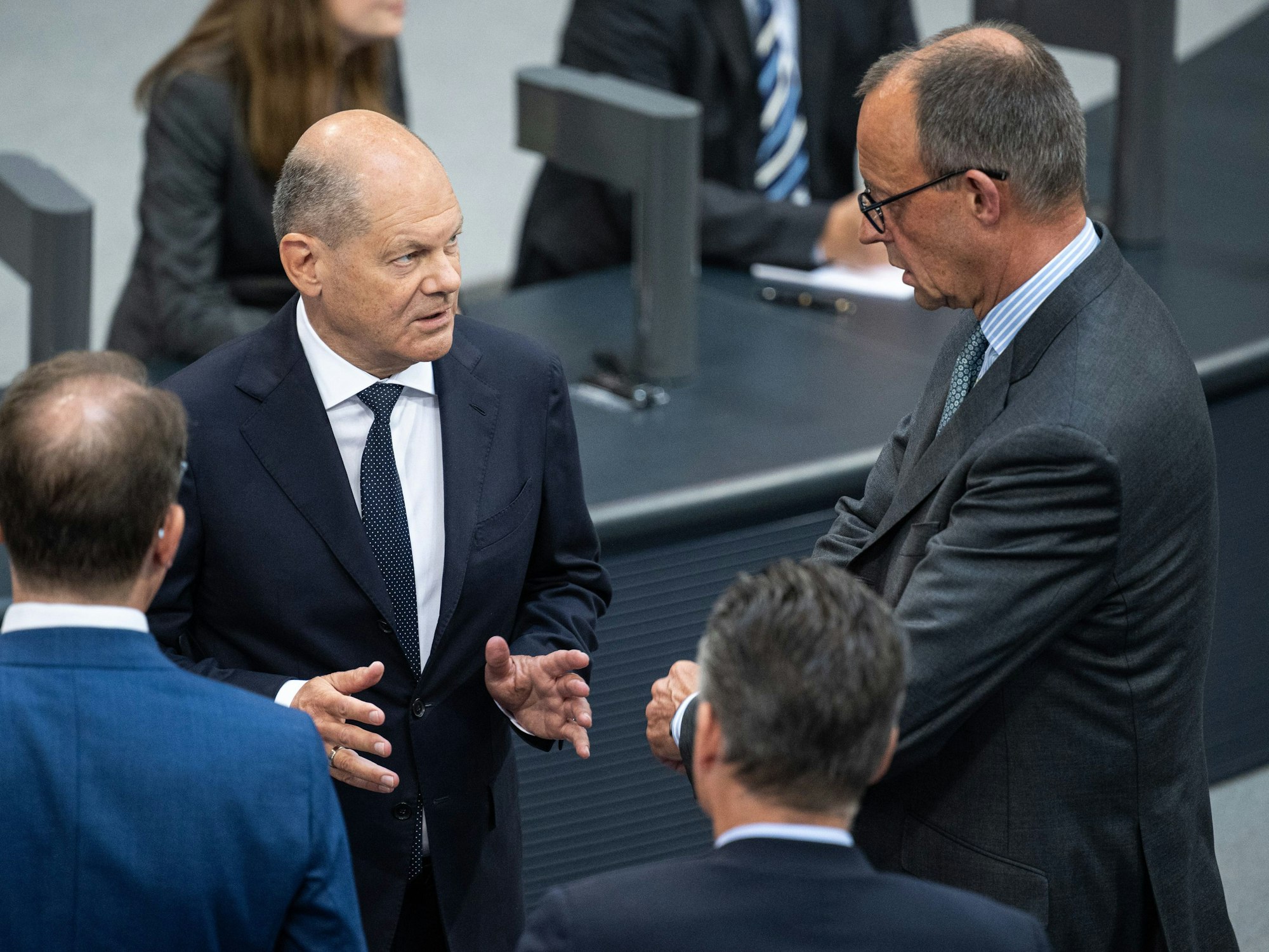 Bundeskanzler Olaf Scholz (SPD, l) und Friedrich Merz, CDU-Bundesvorsitzender und Fraktionsvorsitzender der CDU/CSU-Fraktion im Bundestag, unterhalten sich am 26. Juni 2024 im Deutschen Bundestag.