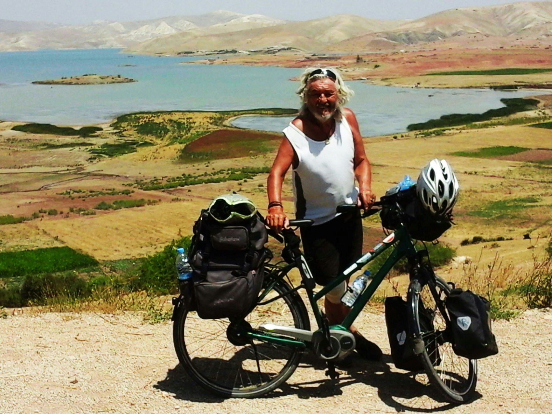 Wolfgang Hollmer mit seinem Fahrrad vor einem großen Landschaft in Marokko.