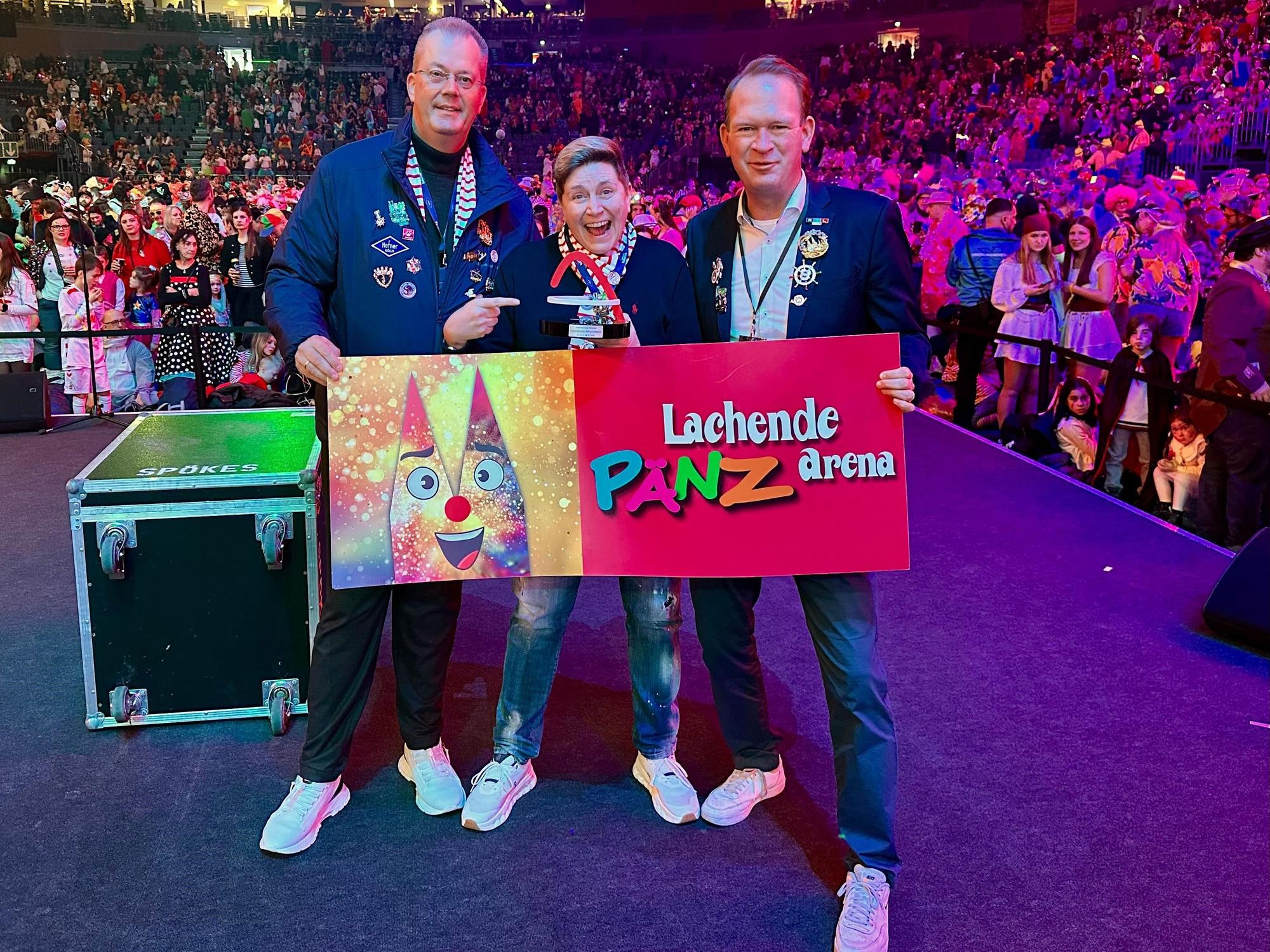 Stefan Löcher überreicht einen Award an Nathalie Drmota und Michael Burgmer.