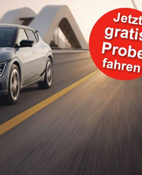 Ein grauer Kia EV6 GT-line fährt in der Abenddämmerung schnell auf einer Autobahn.