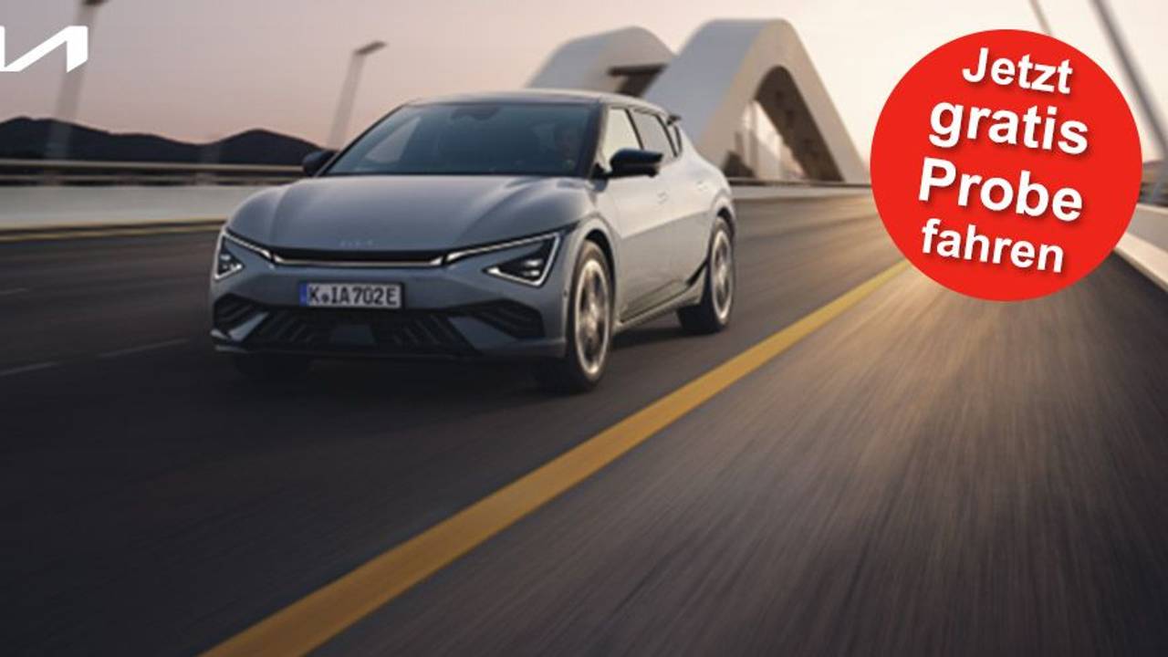 Ein grauer Kia EV6 GT-line fährt in der Abenddämmerung schnell auf einer Autobahn.