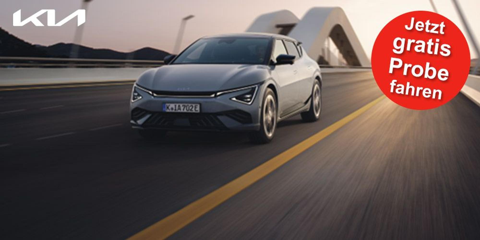 Ein grauer Kia EV6 GT-line fährt in der Abenddämmerung schnell auf einer Autobahn.