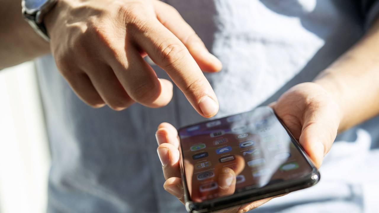 Ein Mann tippt auf einem Handy.