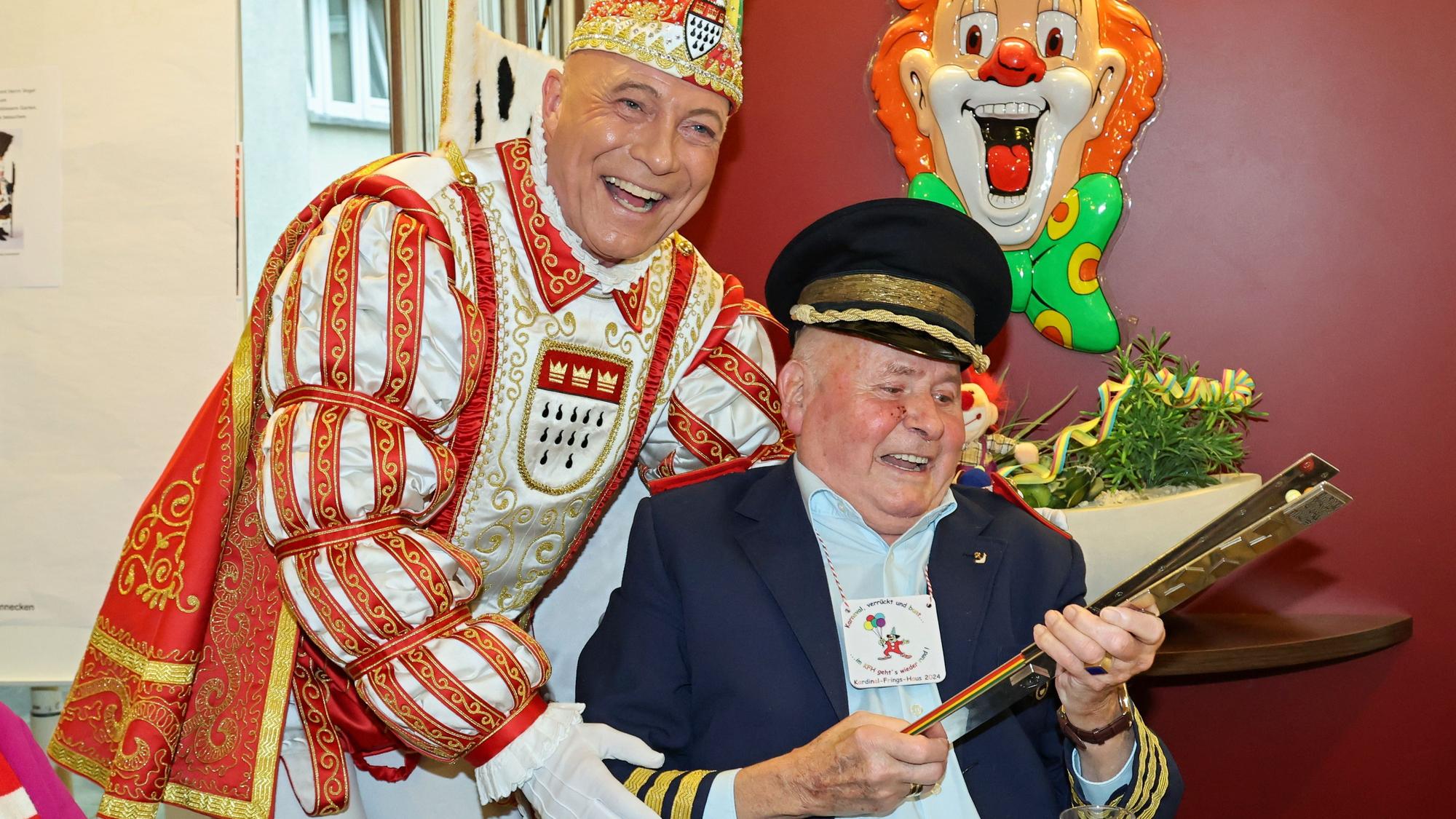 Prinz René gibt einem älteren Mann seine Pritsche.