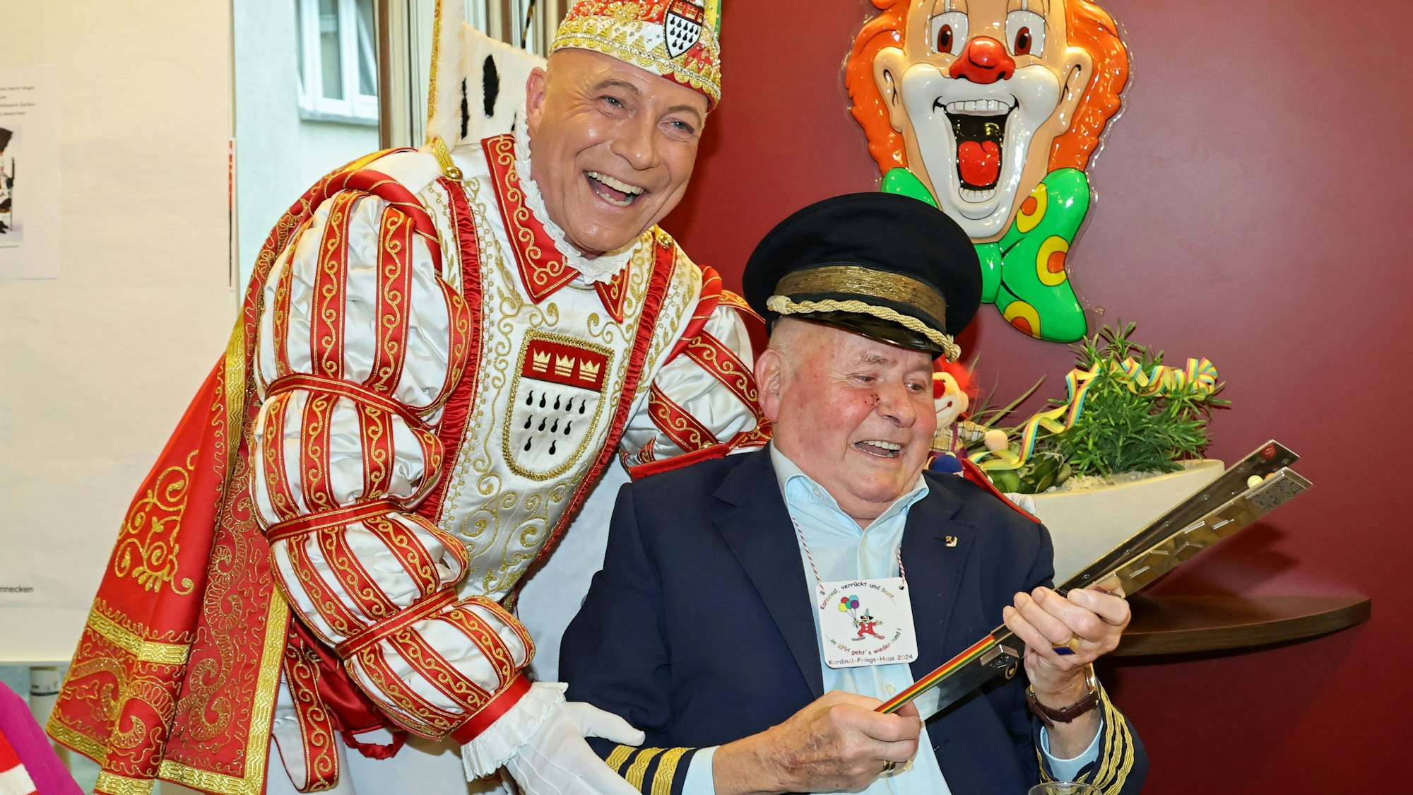 Prinz René gibt einem älteren Mann seine Pritsche.