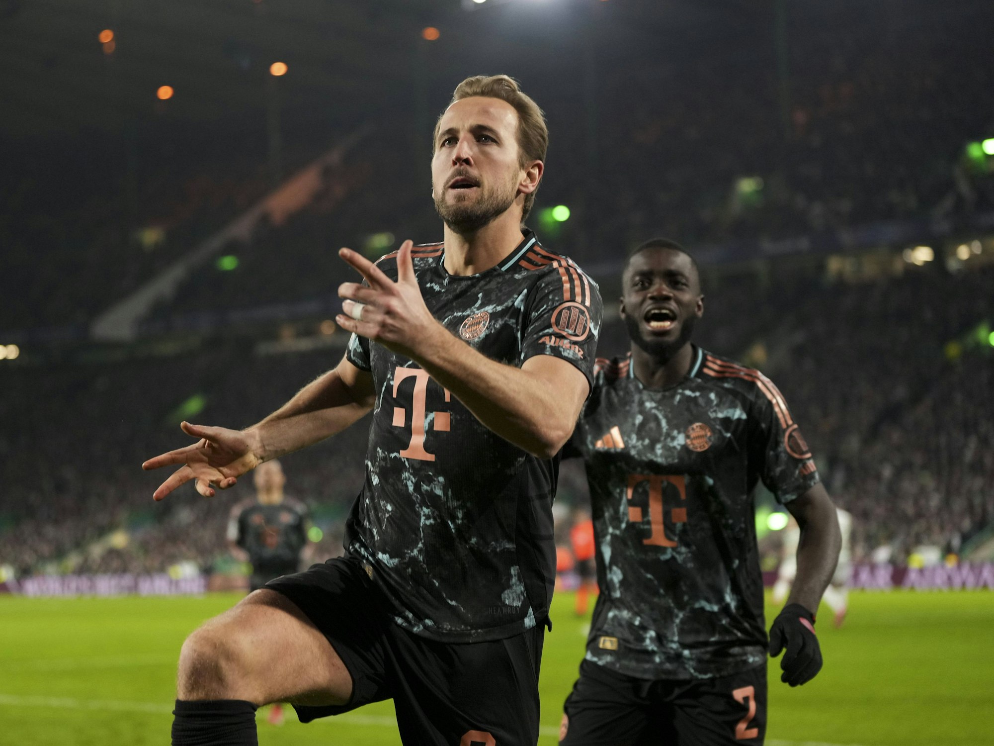 Harry Kane bejubelt einen Treffer, im Hintergrund freut sich Dayot Upamecano.