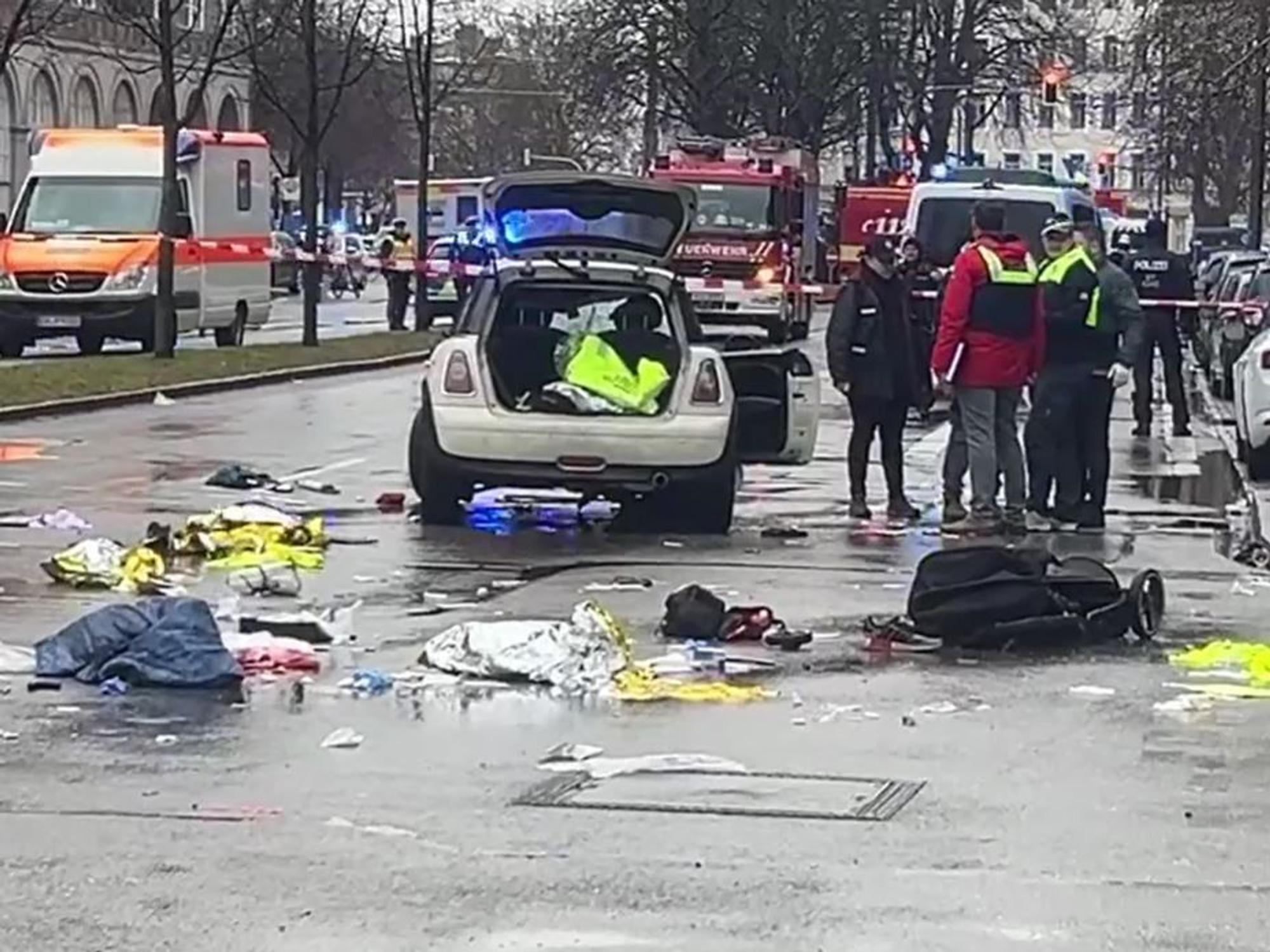 In der Münchner Innenstadt ist ein Fahrzeug in eine Menschengruppe gefahren. Polizisten untersuchen ein Auto in der Nähe des Einsatzortes.