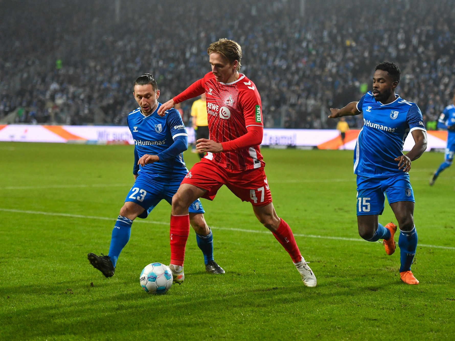 Baris Atik (l-r) von Magdeburg, Mathias Olesen vom 1. FC Köln und Daniel Heber von Magdeburg kämpfen um den Ball.