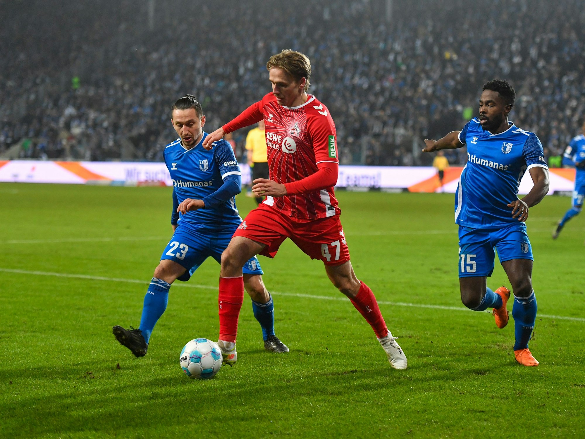Baris Atik (l-r) von Magdeburg, Mathias Olesen vom 1. FC Köln und Daniel Heber von Magdeburg kämpfen um den Ball.