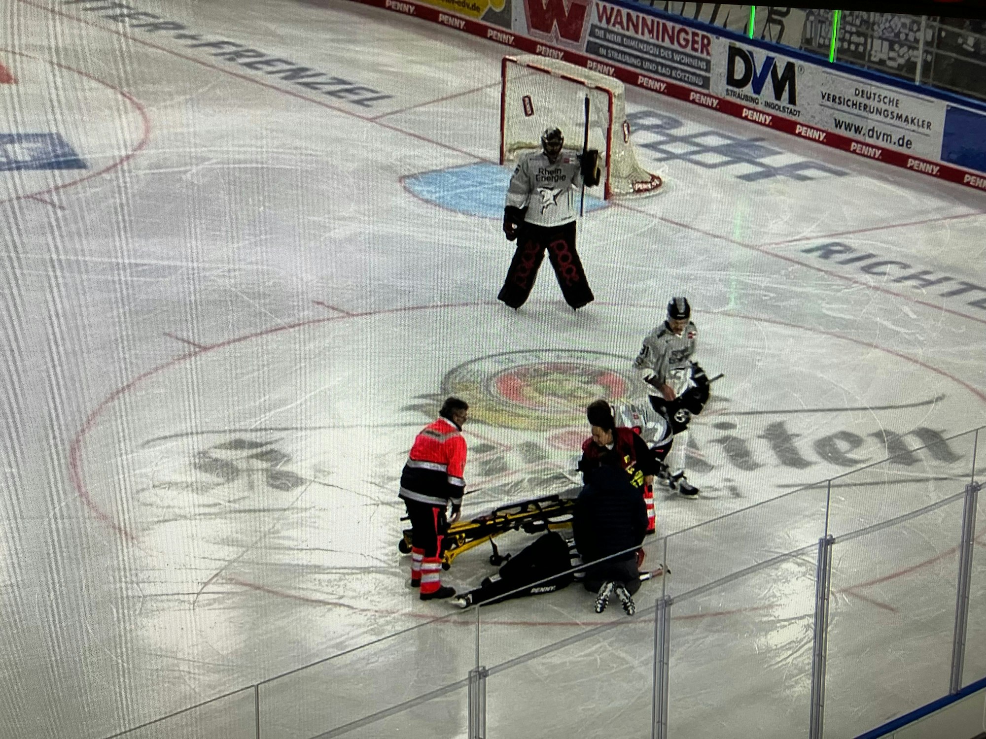 Schiedsrichter Martin Frano liegt auf dem Eis, neben ihm wird eine Trage bereitgemacht.