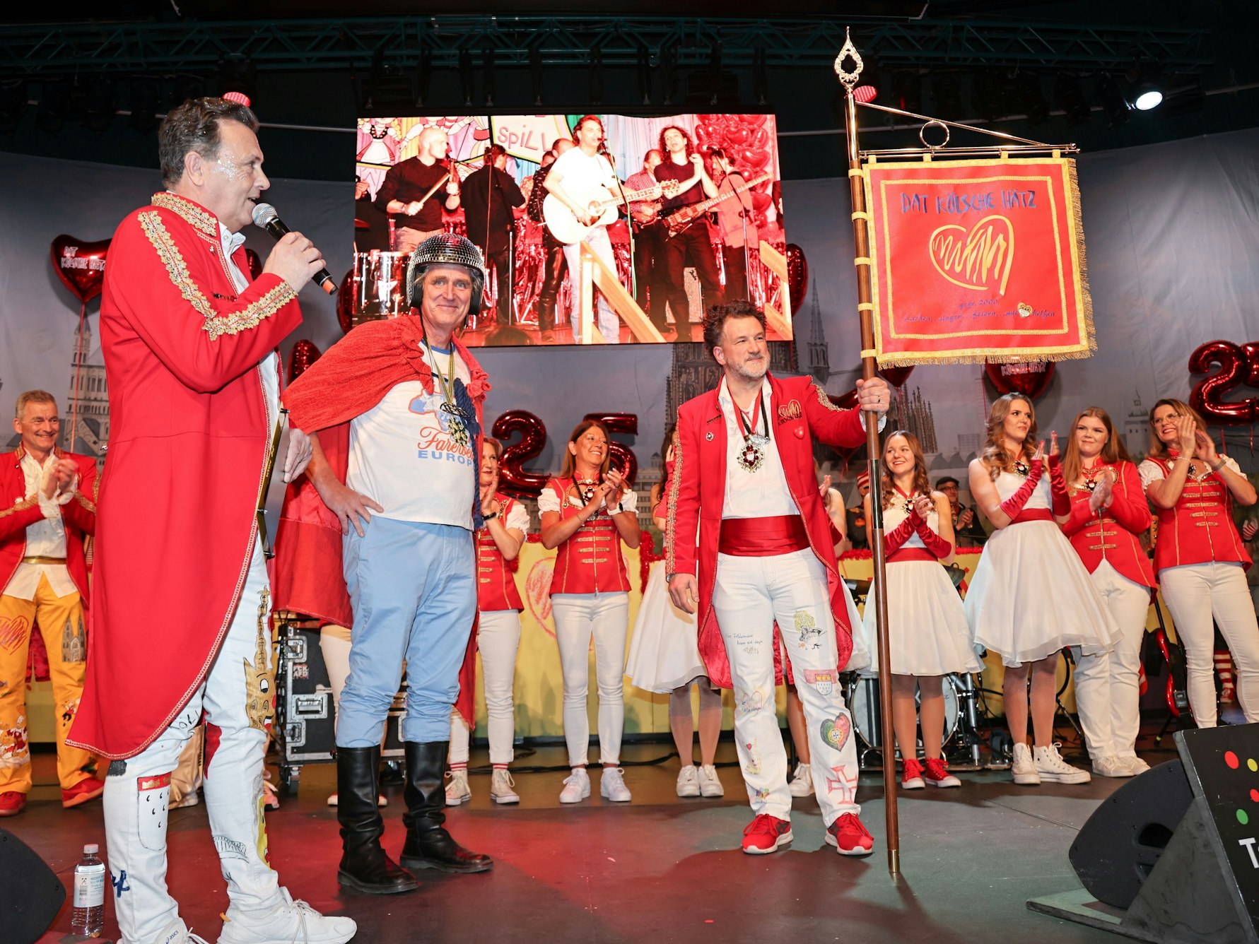 Der Vorstand von „Dat Kölsche Hätz“ präsentiert die Fahne.