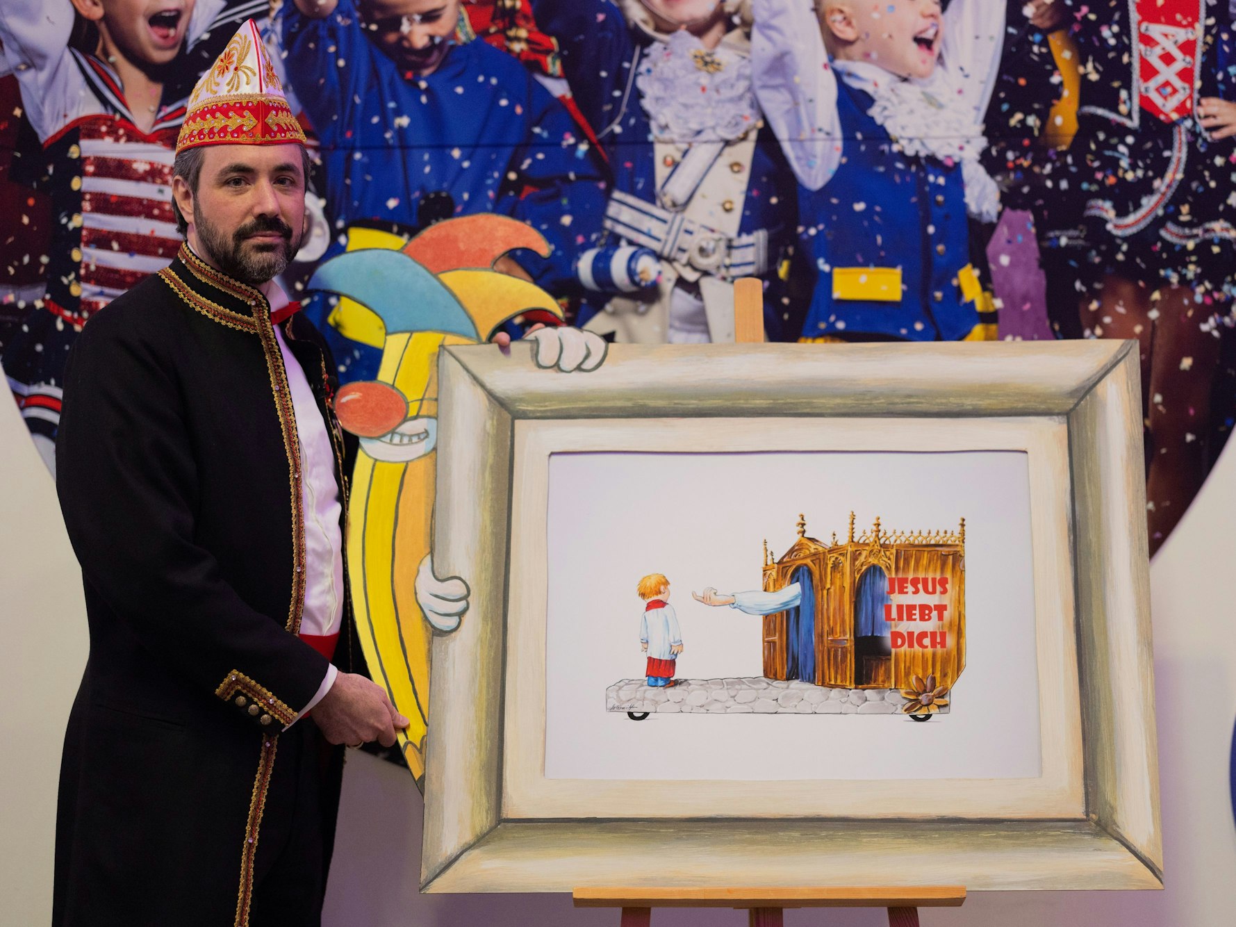 Zugleiter Marc Michelske präsentiert bei einer Pressekonferenz des Festkomitees Kölner Karneval eine Skizze.