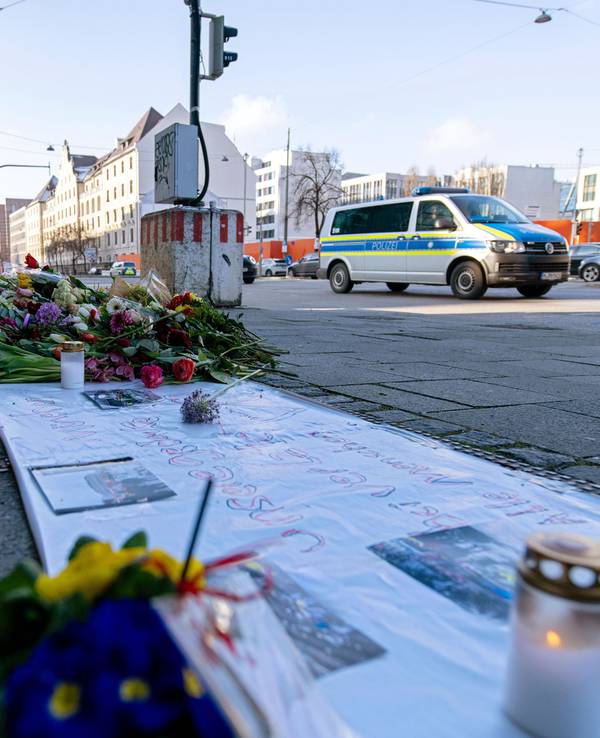 Ein Einsatzfahrzeug der Polizei fährt an Blumen und Kerzen nahe der Stelle in der Innenstadt vorbei, wo am Donnerstag in eine Gruppe von Demonstranten gefahren war.