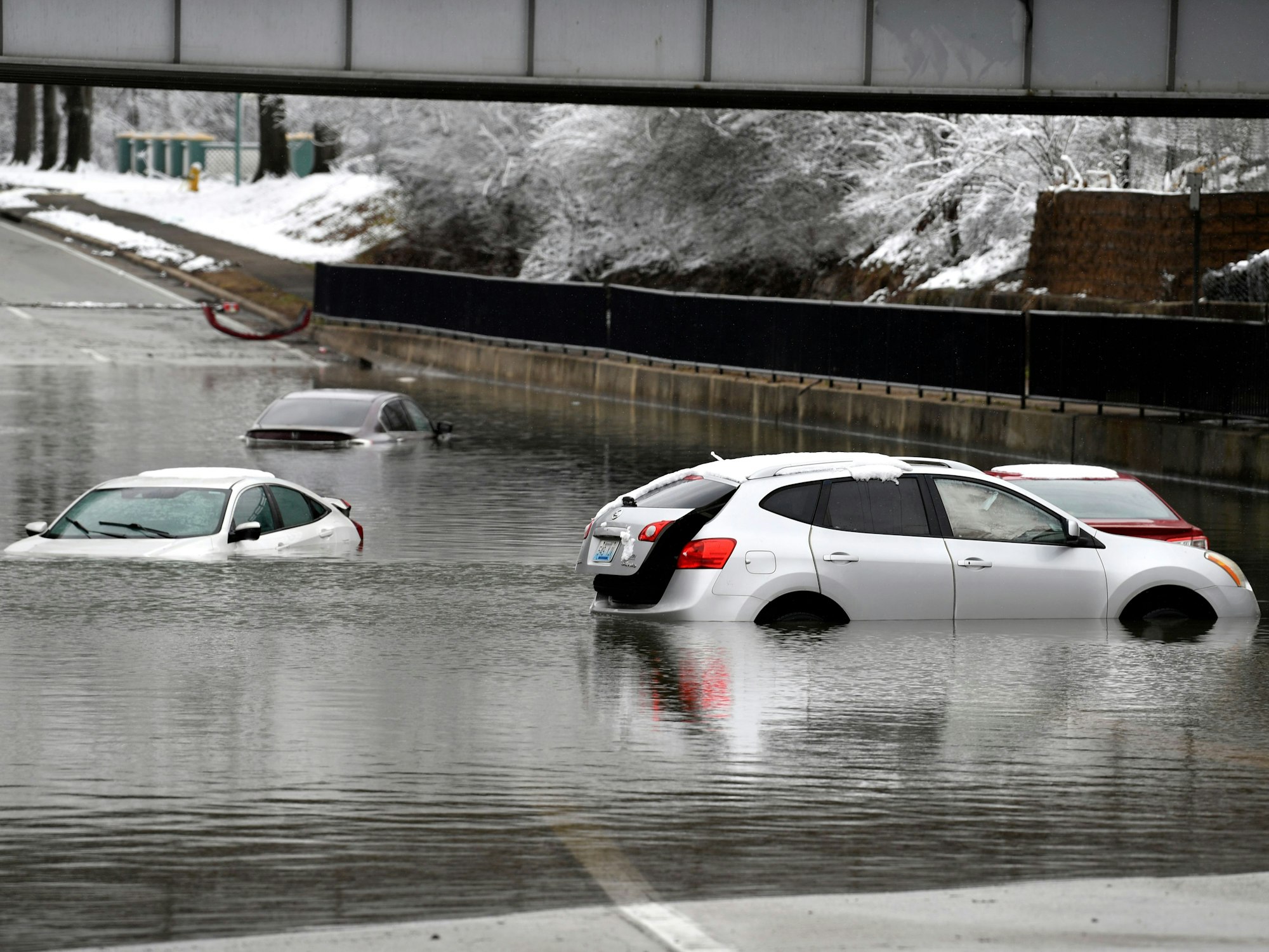 Eine Unterführung steht unter Wasser, einige Autos sind überflutet.