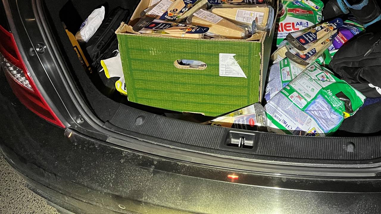 Im Kofferraum eines Autos steht eine Kiste voll mit Parmesankäse.