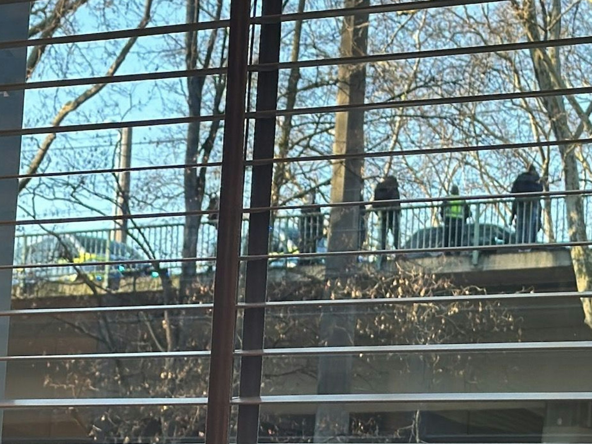 Mehrere Personen stehen auf einer Brücke.
