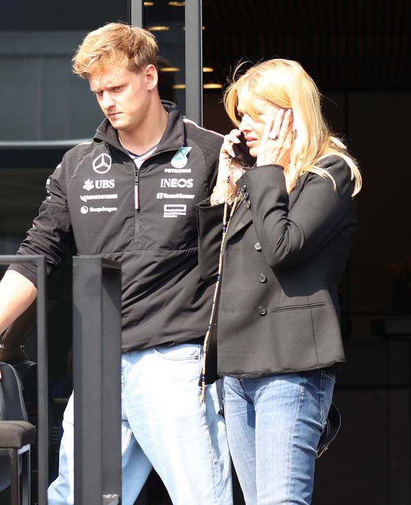 Corinna Schumacher telefoniert, ihr Sohn Mick steht neben ihr.