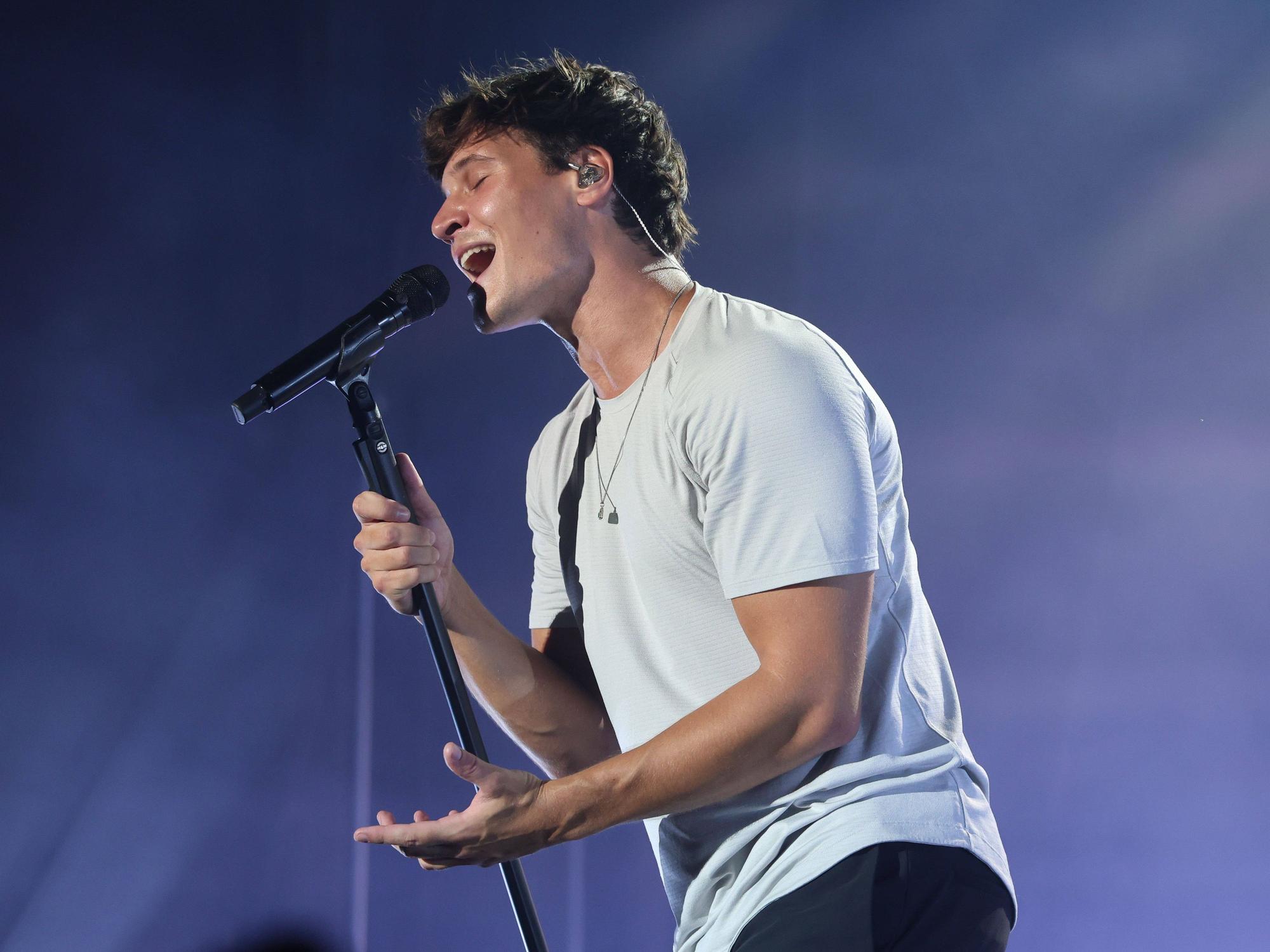 Wincent Weiss singt in ein Mikro.