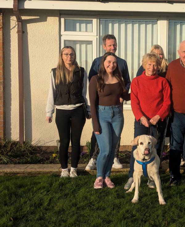 Foto der 2017 gestohlenen Labradorhündin Daisy im Garten mit ihrer Familie, aufgenommen im Februar 2025