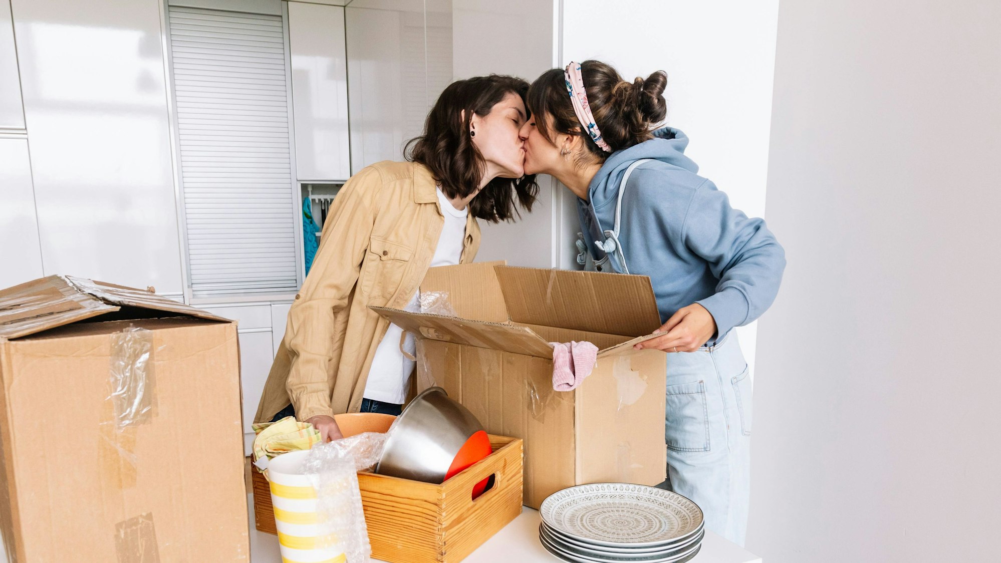 Junges Paar zieht um und küsst sich in der Küche