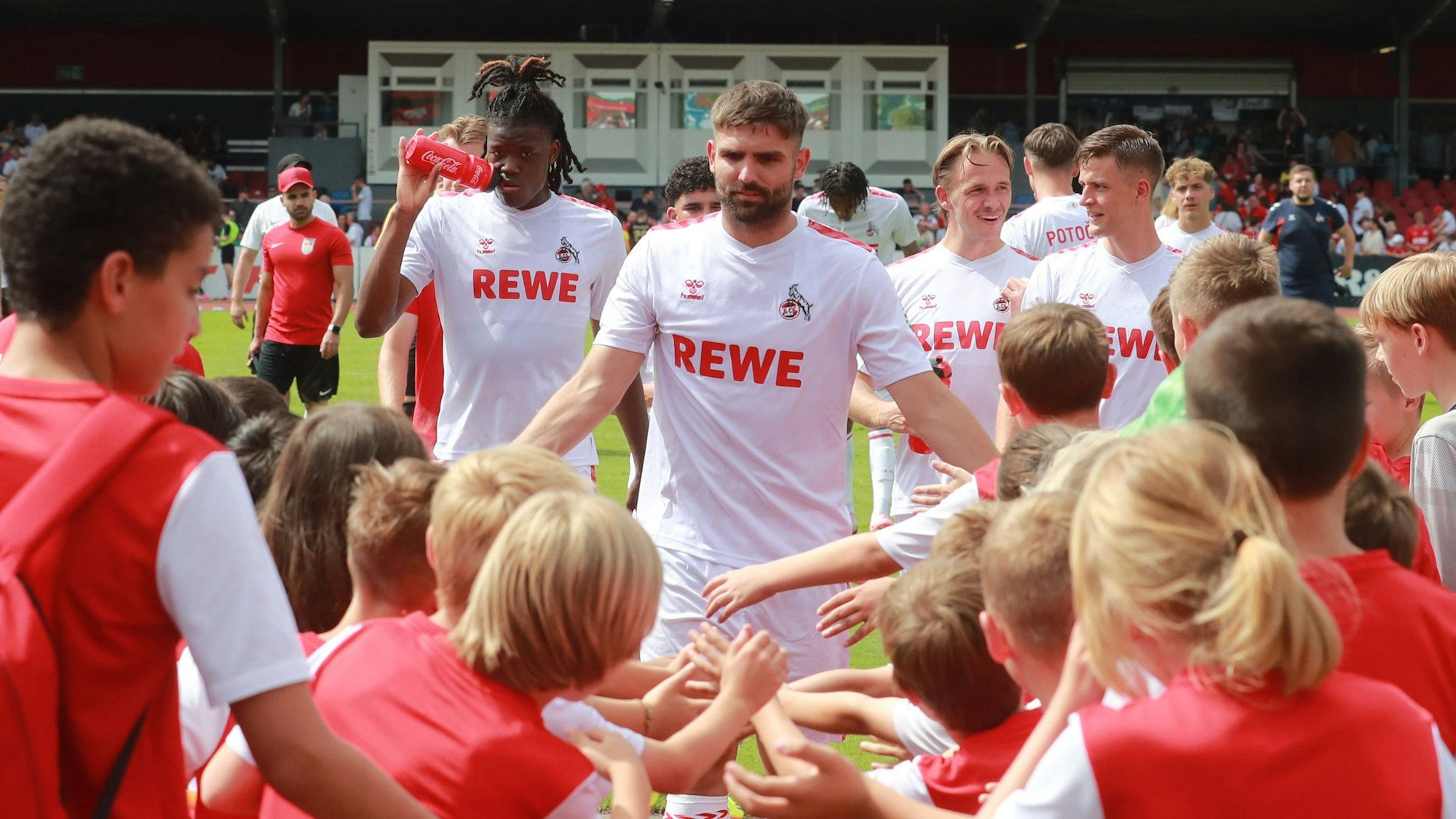 Nikola Soldo klatscht nach einem Testspiel des 1. FC Köln mit Kindern ab.