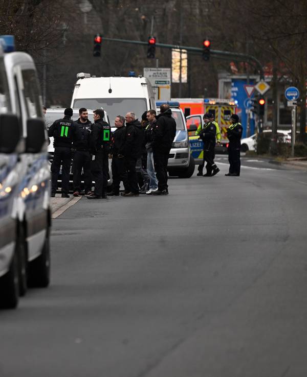 Polizeikräfte stehen an einem Einsatzort.