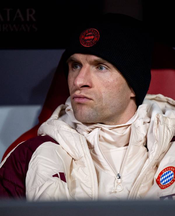 Thomas Müller sitzt auf der Bank und guckt aufs Spielfeld.
