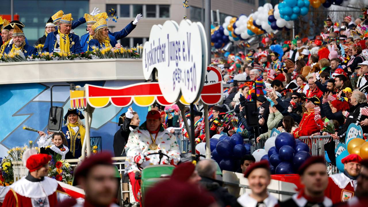 Jecken auf einer Tribüne und kostümierte Narren auf dem Rosenmontagszug 2023 unter dem Motto 200 Jahre Kölner Karneval Ov Krüz oder quer in Köln.