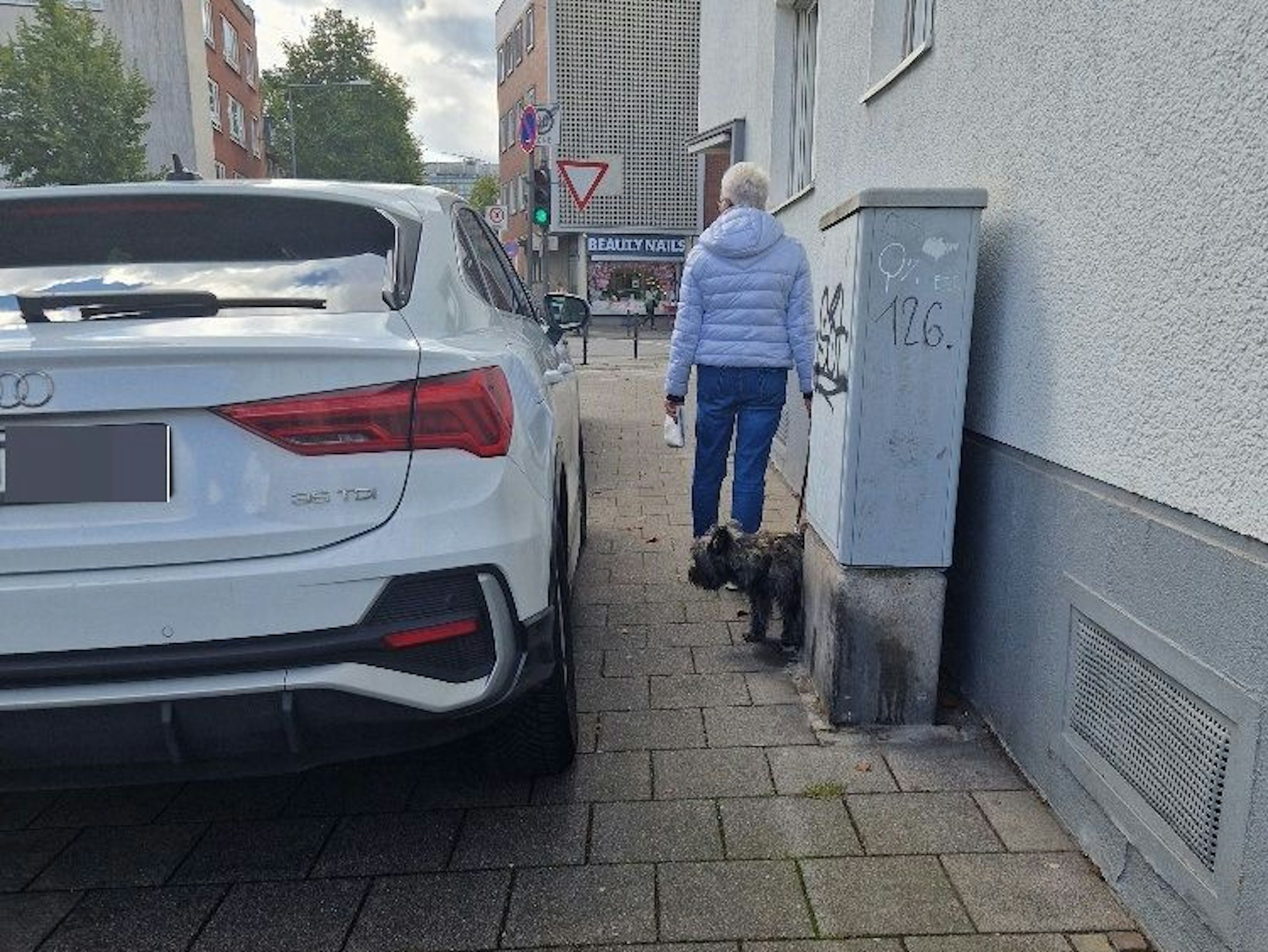 Ein SUV steht weit auf dem Gehweg.