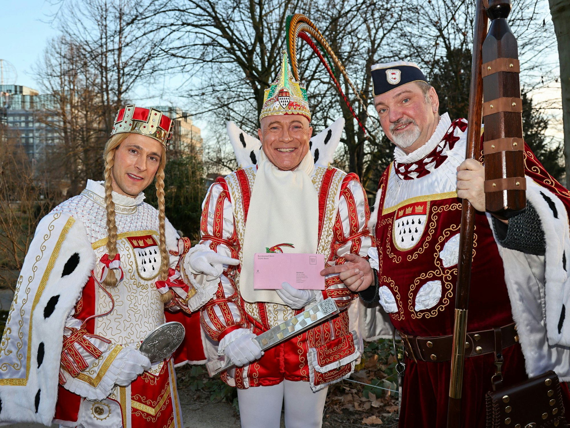 Das Kölner Dreigestirn mit Wahlbrief in der Hand.