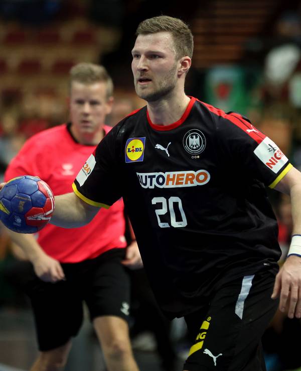 Philipp Weber mit Ball in der Hand in Aktion, im Hintergrund ist Jesper Madsen zu sehen.