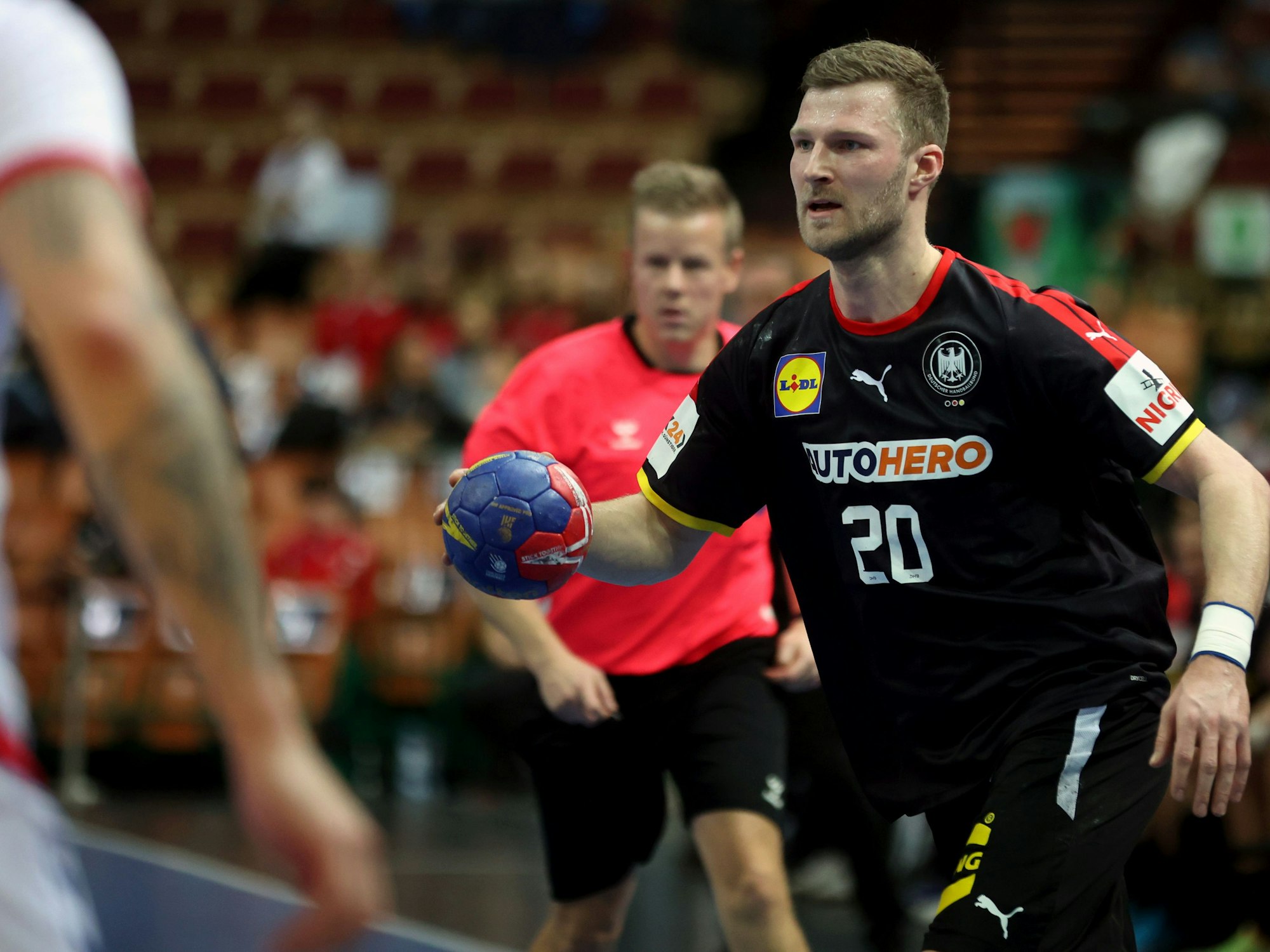 Philipp Weber mit Ball in der Hand in Aktion, im Hintergrund ist Jesper Madsen zu sehen.