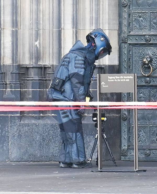 Ein Entschärfer nähert sich am Freitagmittag (21. Februar 2025) einem herrenlosen Koffer, der am Hauptportal des Doms hängt.