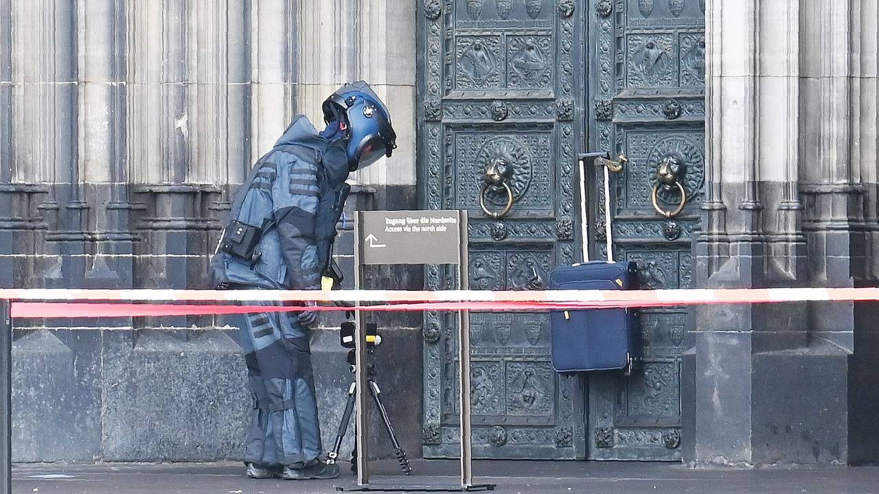 Ein Entschärfer nähert sich am Freitagmittag (21. Februar 2025) einem herrenlosen Koffer, der am Hauptportal des Doms hängt.