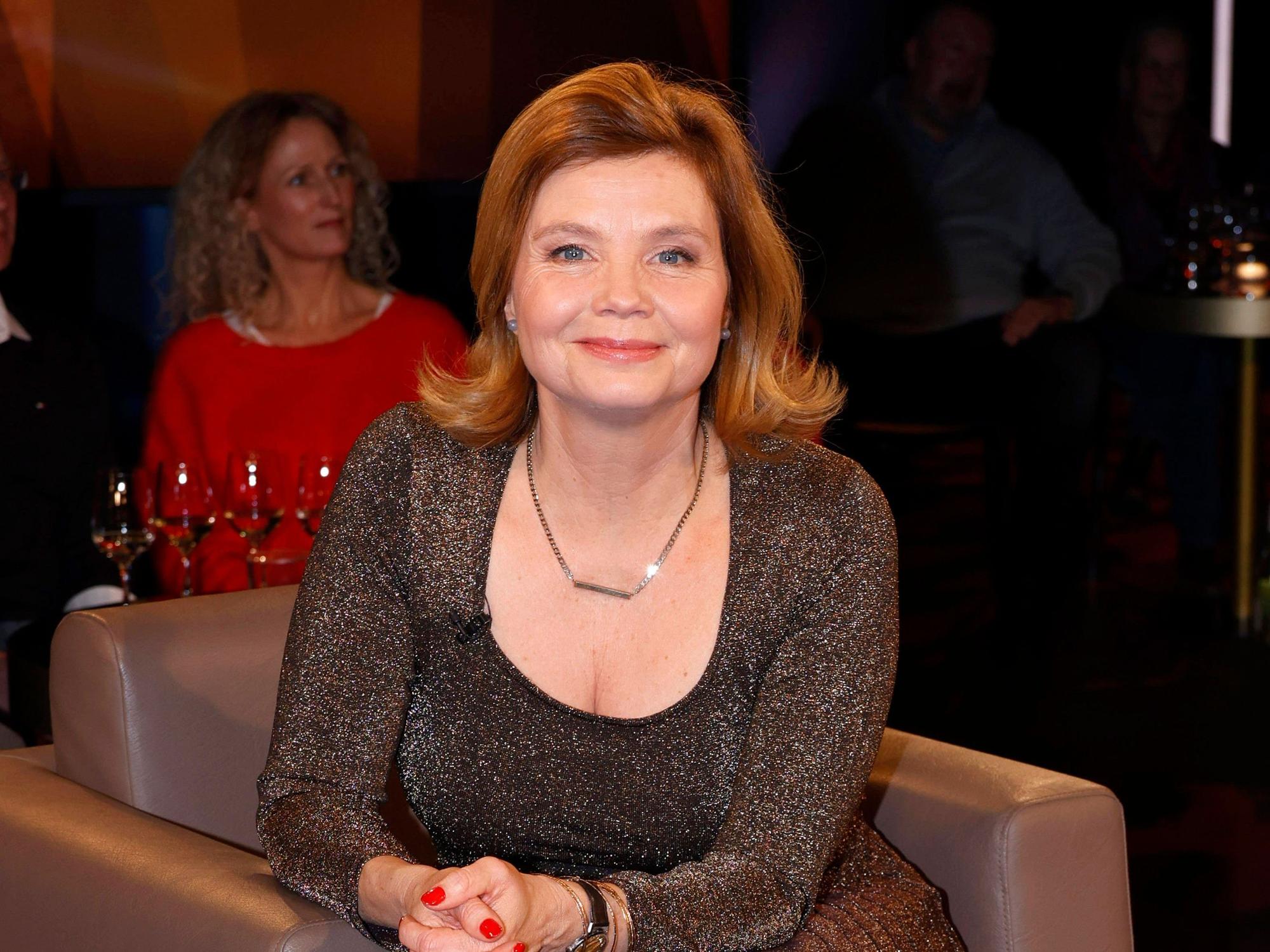 Annette Frier auf einem Sessel bei einer TV-Aufzeichnung.