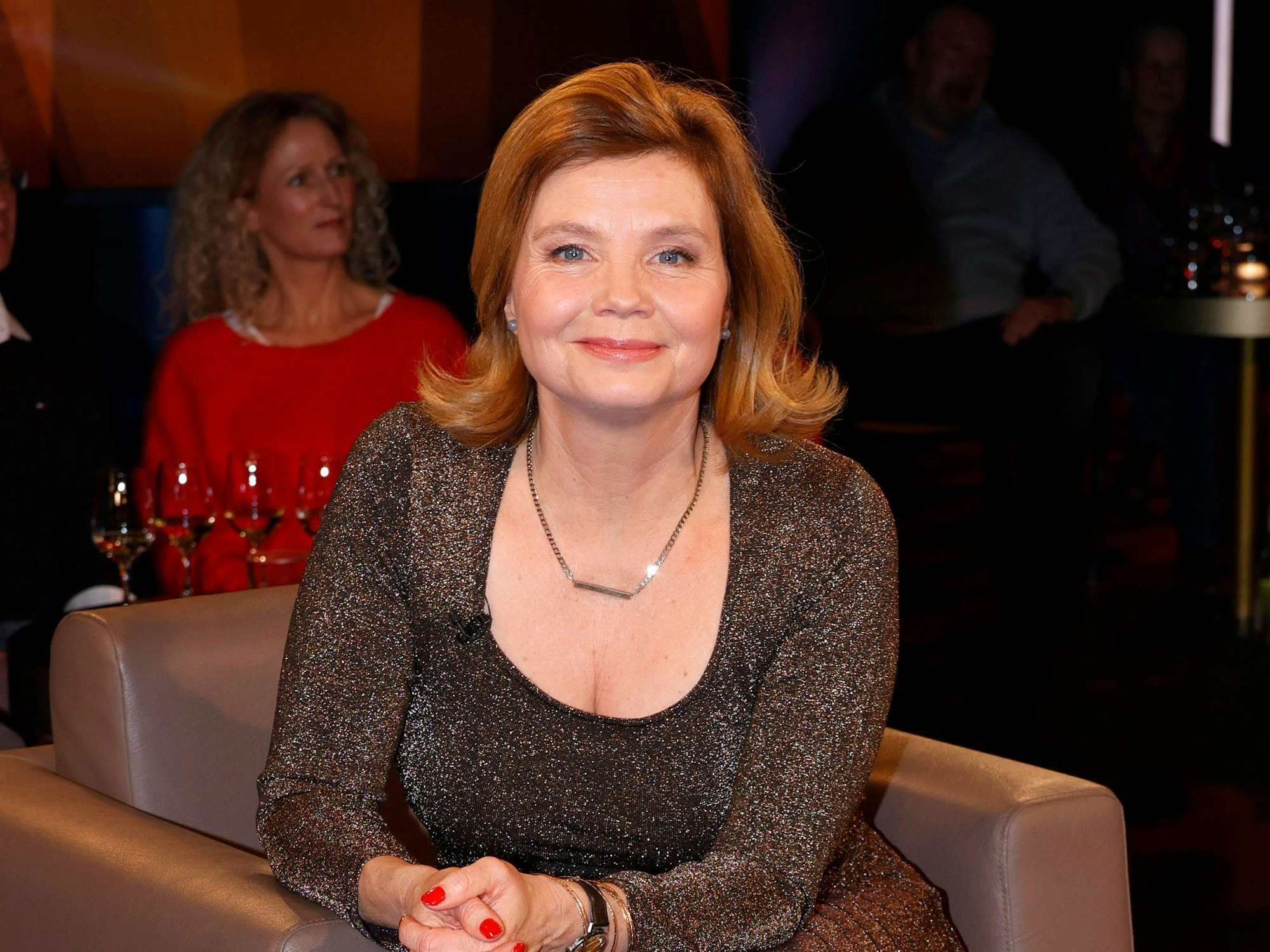 Annette Frier auf einem Sessel bei einer TV-Aufzeichnung.
