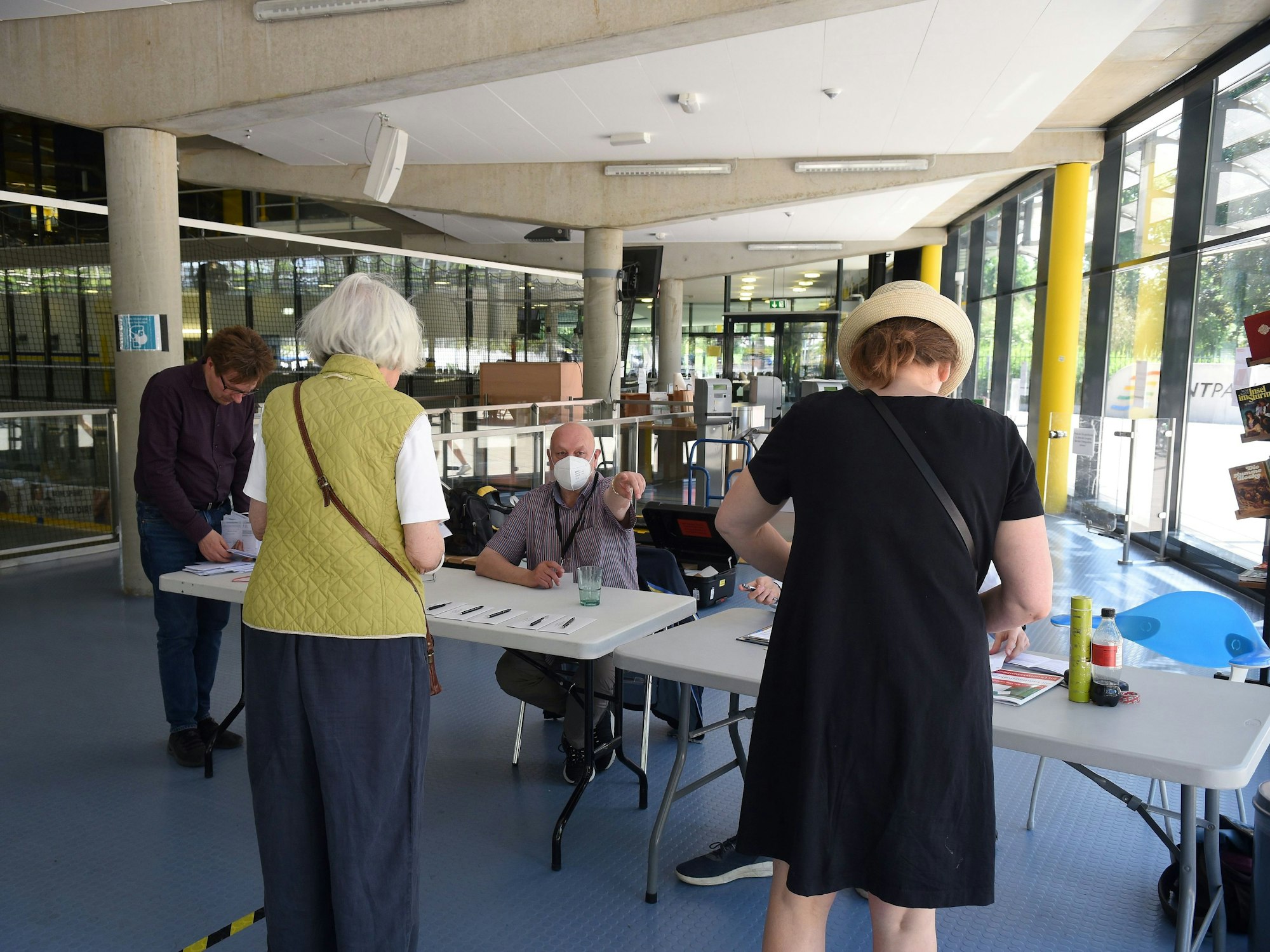 Frauen und Männer im Wahllokal im Lentpark in Köln.