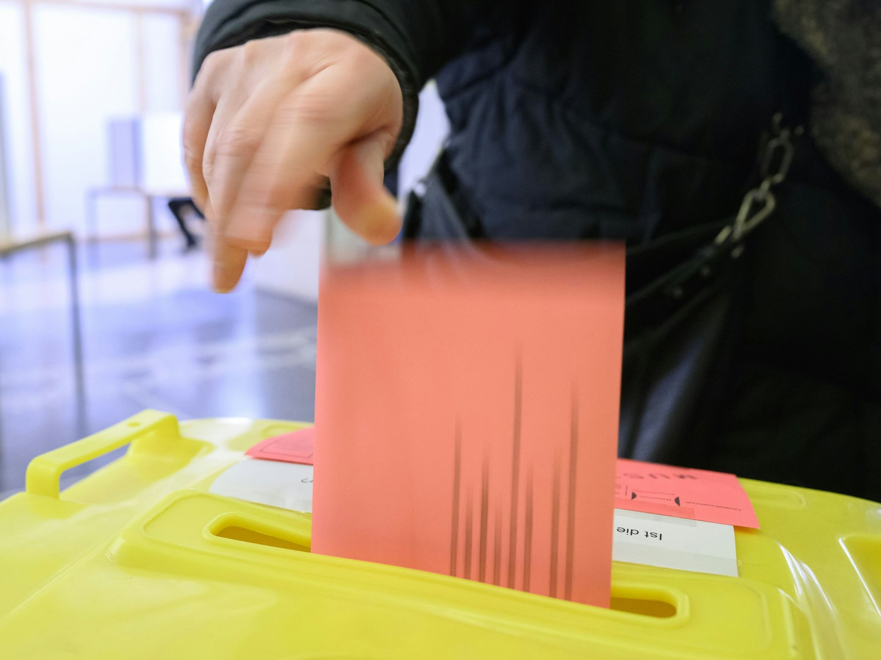 Eine Frau wirft ihren Wahlzettel für die Bundestagswahl 2025 in der Briefwahlstelle im Neuen Rathaus in eine Urne.