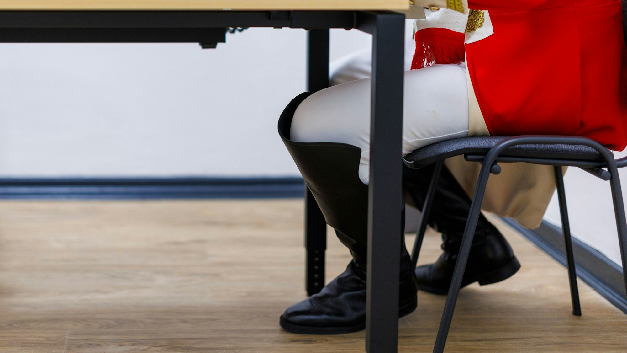 15.02.2025, Nordrhein-Westfalen, Duisburg: Ein Mann in Karnevalsuniform sitzt an einem Tisch in der Wahlkabine und gibt seine Stimme zur Bundestagswahl 2025 ab.