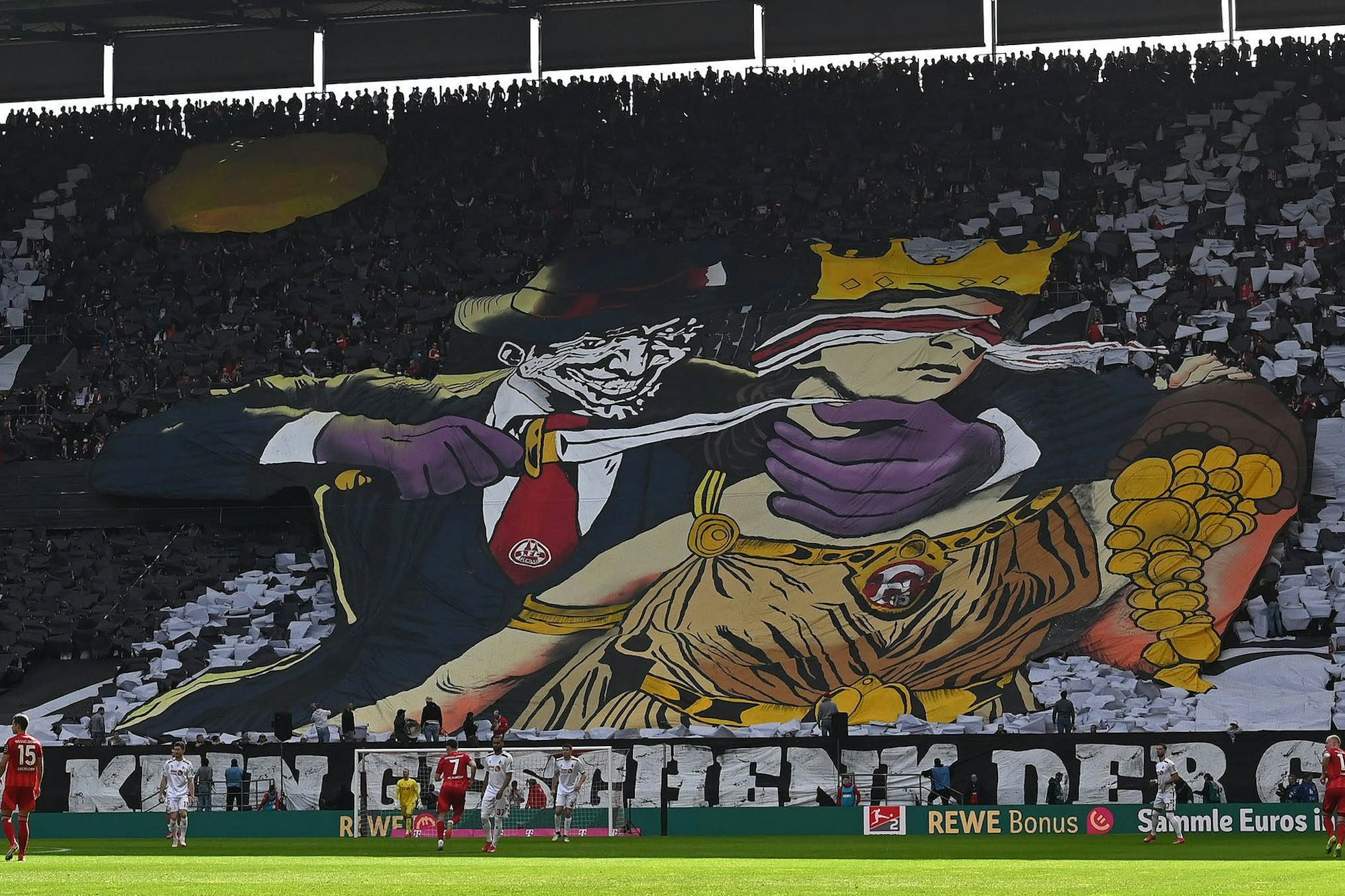 Die viel diskutierte FC-Choreo gegen Düsseldorf: Glücksgöttin Fortuna wird mit einem Messer attackiert.