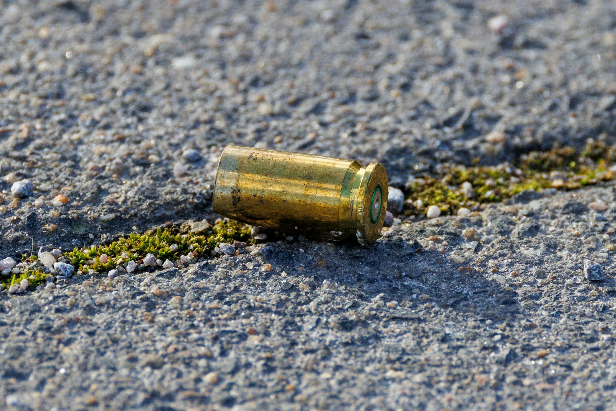 Eine Patronenhülse aus einer Polizeiwaffe liegt auf dem Boden des Parkplatzes der historischen Stadthalle.