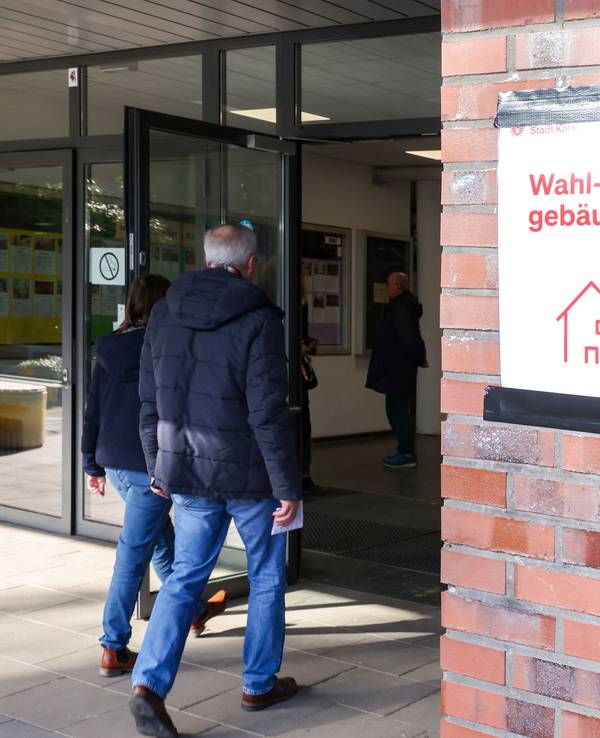 Menschen gehen ins Wahllokal an der Montessori-Schule in Köln-Bickendorf.