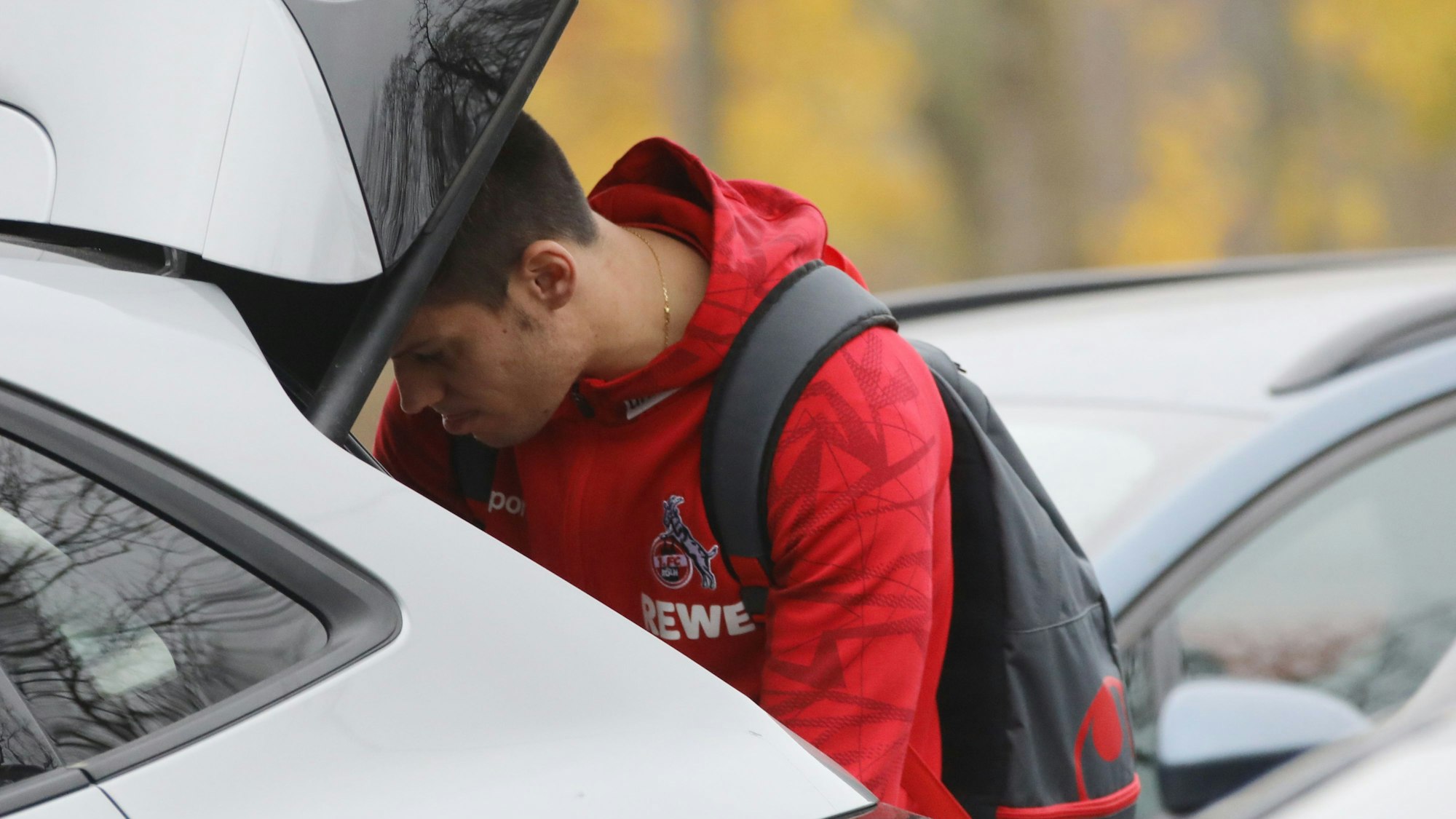 Jorge Meré verstaut Gepäck im Kofferraum seines Autos am Trainingsgelände des 1. FC Köln.
