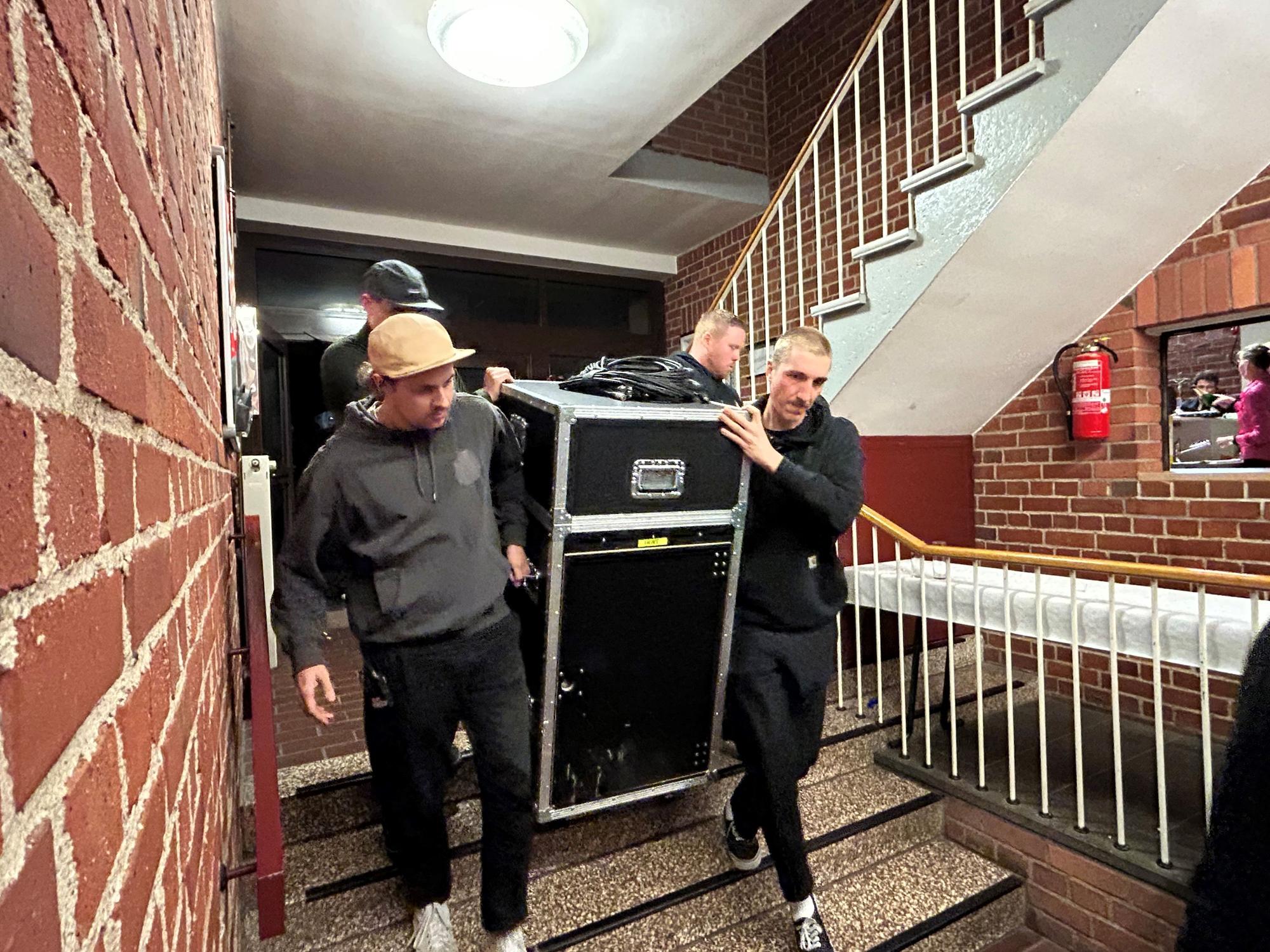 Die Crew von Cat Ballou trägt das Equipment für den Auftritt.