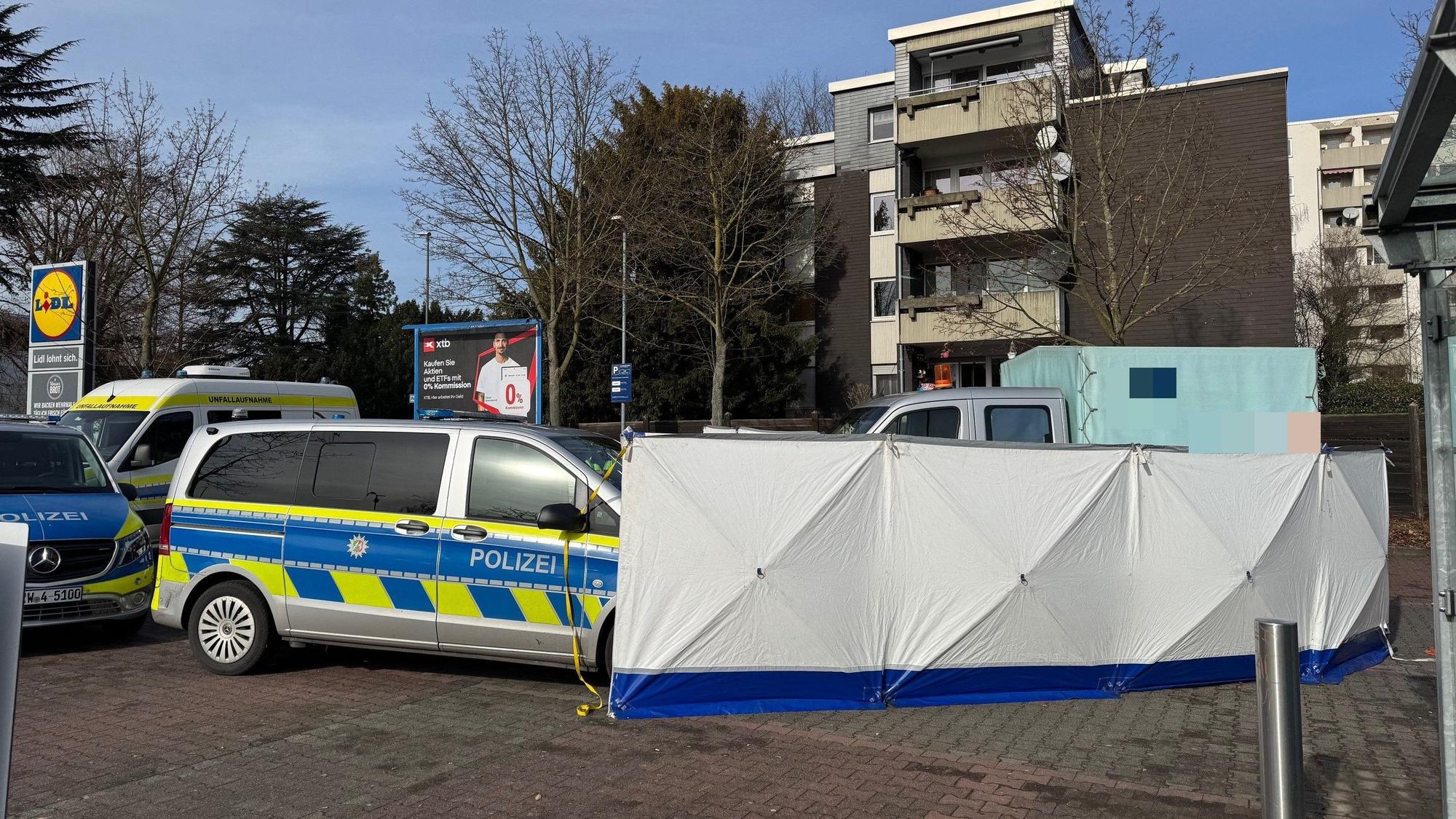 Ein Kleinlaster steht hinter einem Sichtschutz, daneben Einsatzfahrzeuge der Polizei.